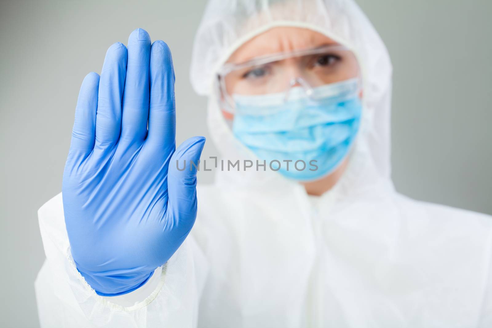 Lab scientist doctor wearing biohazard protective suit hand gest by Plyushkin