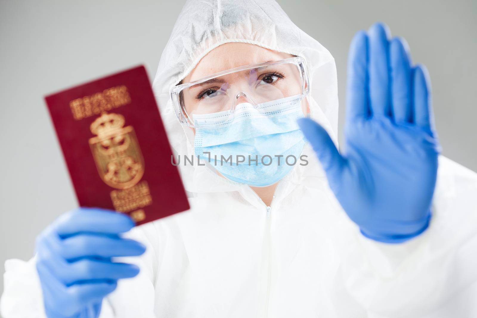 Security officer at airport customs security check holding passport, no entry quarantine and isolation order ban, COVID-19 virus disease epidemic, viral Coronavirus global worldwide pandemic outbreak