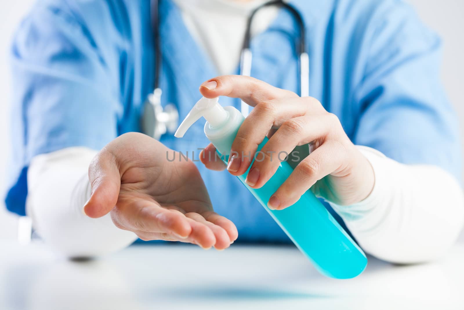 Doctor using hand sanitizer gel by Plyushkin