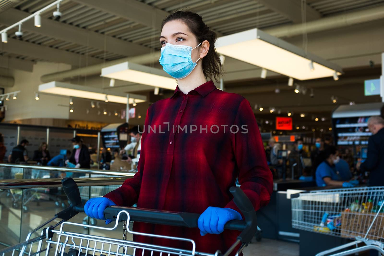 Business as usual,open again as normal,new norm for everyday activities after COVID-19 Coronavirus pandemic end,obligatory personal protective equipment,face mask,gloves.Female shopper pushing trolley