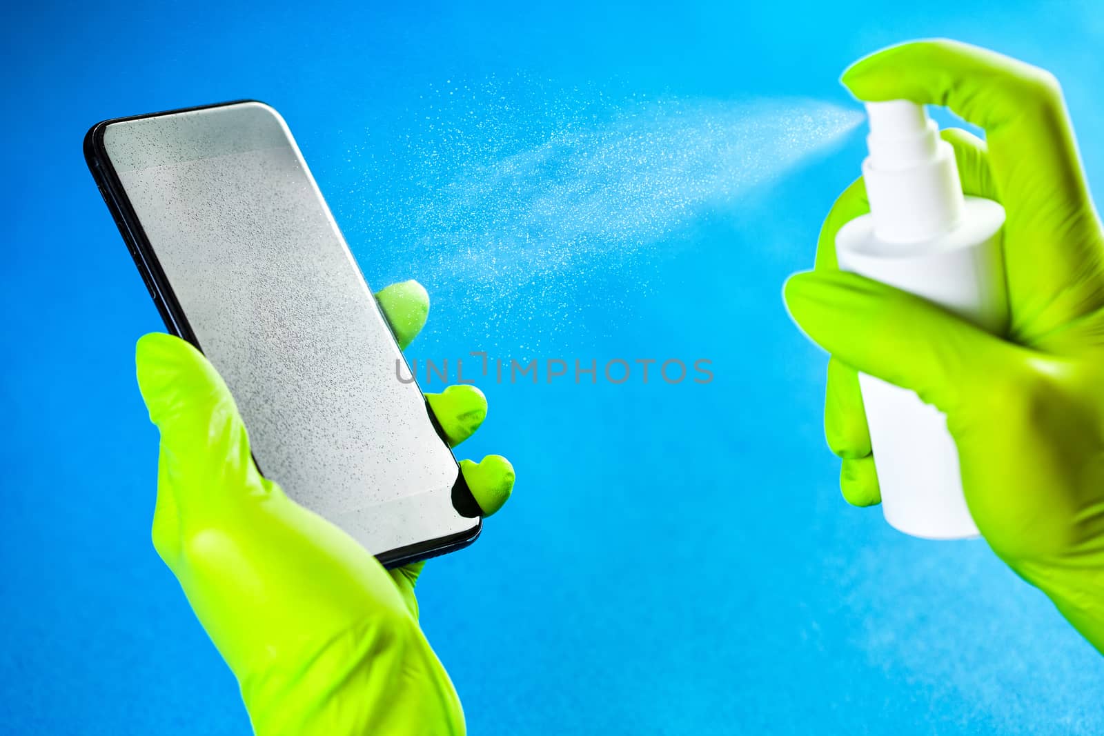 Hands in green gloves spraying antibacterial antiseptic sanitize by Plyushkin