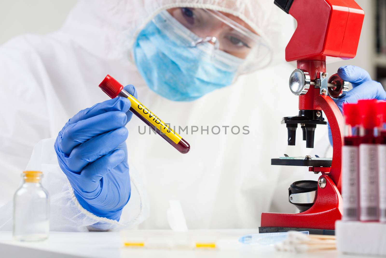 Medical technologist holding a COVID-19 test tube blood sample, contagious dangerous Coronavirus disease global pandemic outbreak, hazard patient specimen laboratory testing analysis procedure