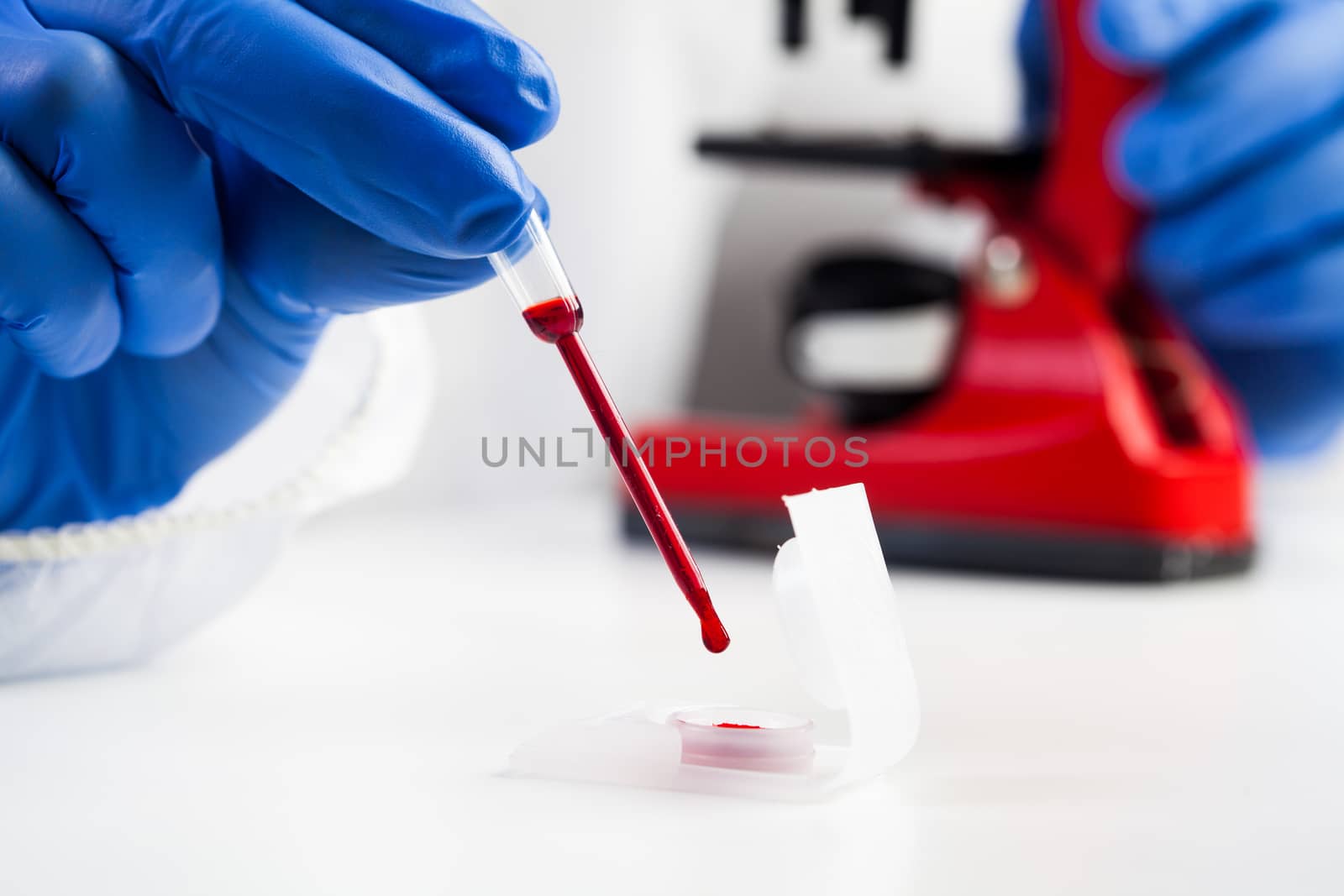 Lab scientist or medical technologist taking a blood sample using pipette dropper from a container, COVID-19 patient blood sample analysis, Coronavirus global pandemic outbreak and health crisis