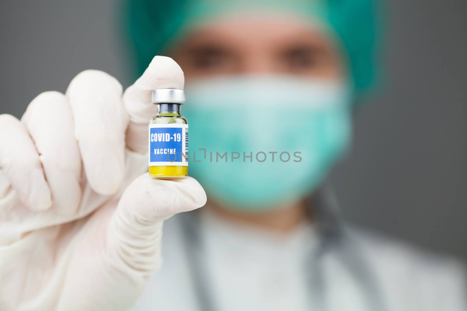 Scientist or doctor holding a vaccine ampoule injection by Plyushkin