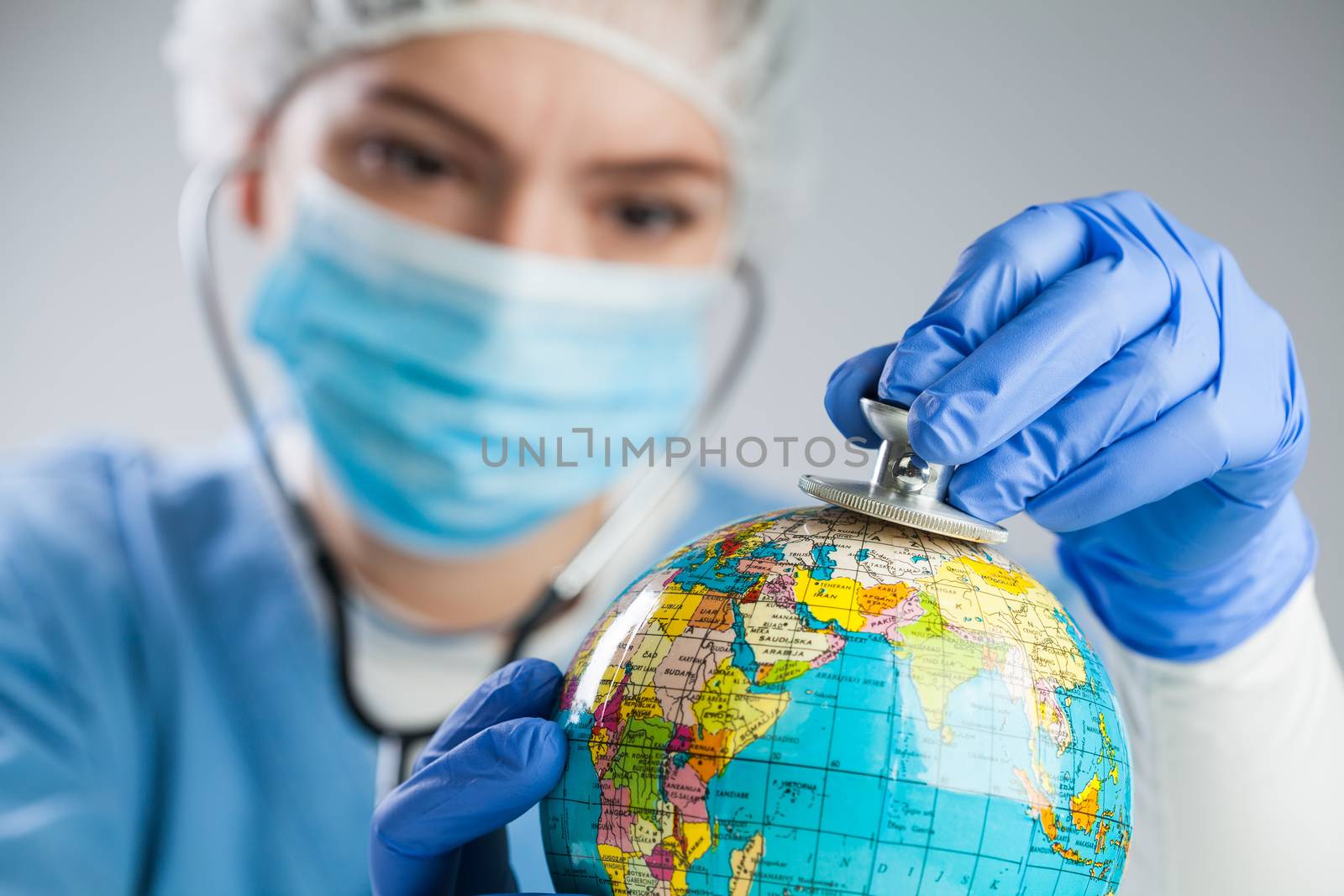 Doctor using a stethoscope to listen to the planet Earth globe a by Plyushkin