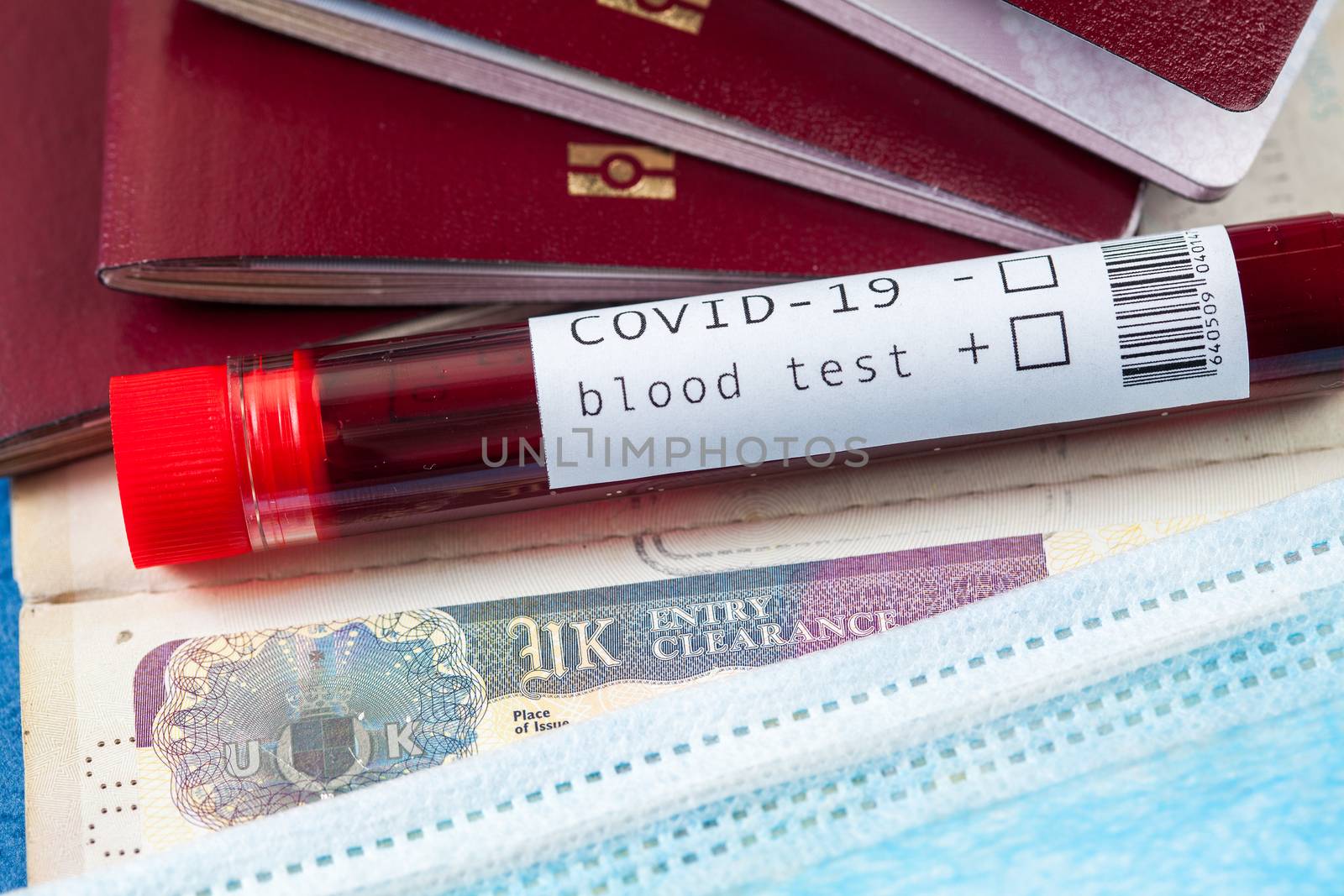 COVID-19 Coronavirus disease global pandemic crisis outbreak,blood sample test tube & several passports with UK British visa,closed borders & cancelled flights,United Kingdom border agency quarantine