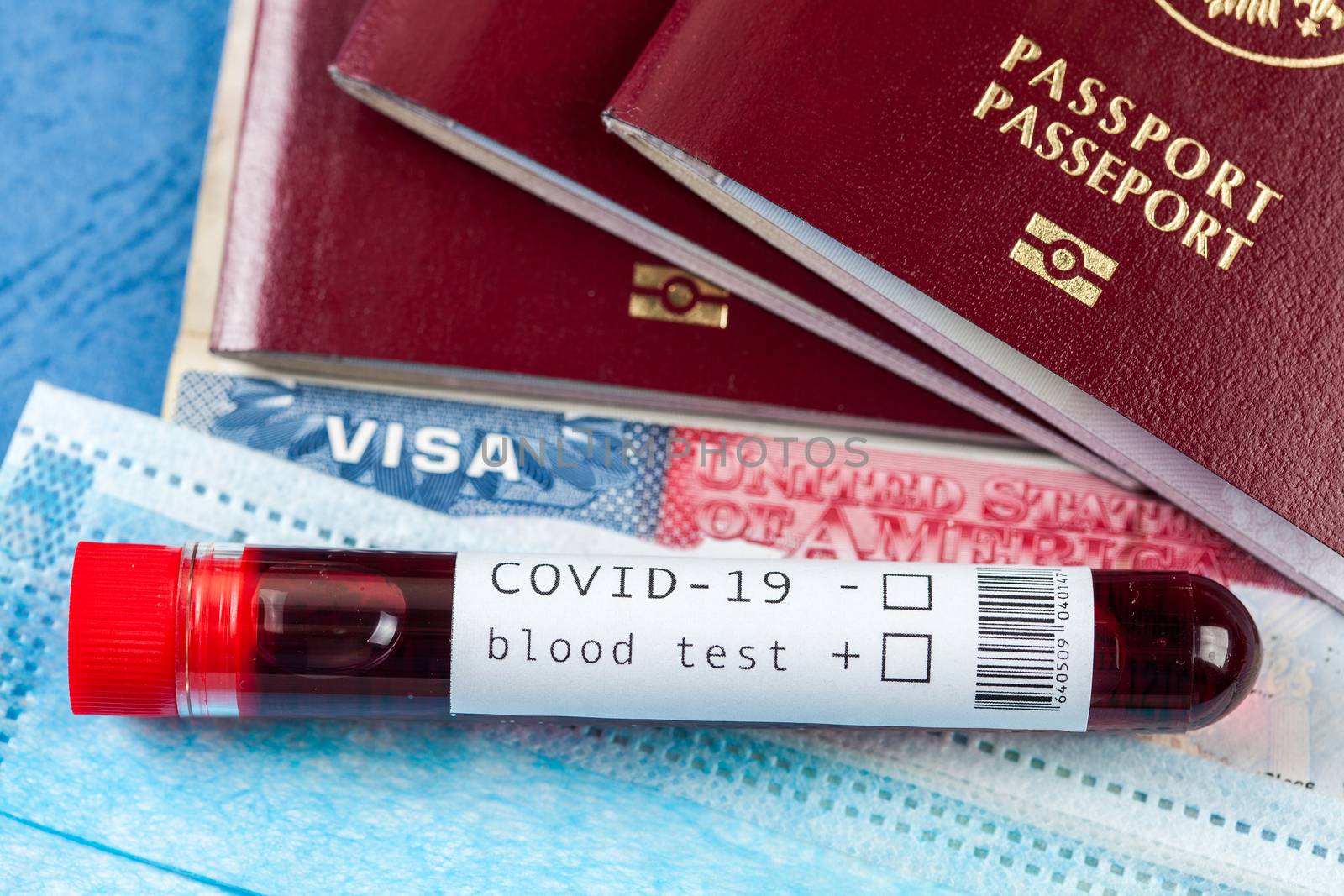 COVID-19 Coronavirus disease, global pandemic outbreak, deadly Wuhan SARS-CoV-2 epidemic, blood sample test tube and several passports with USA American visa, closed borders and cancelled flights