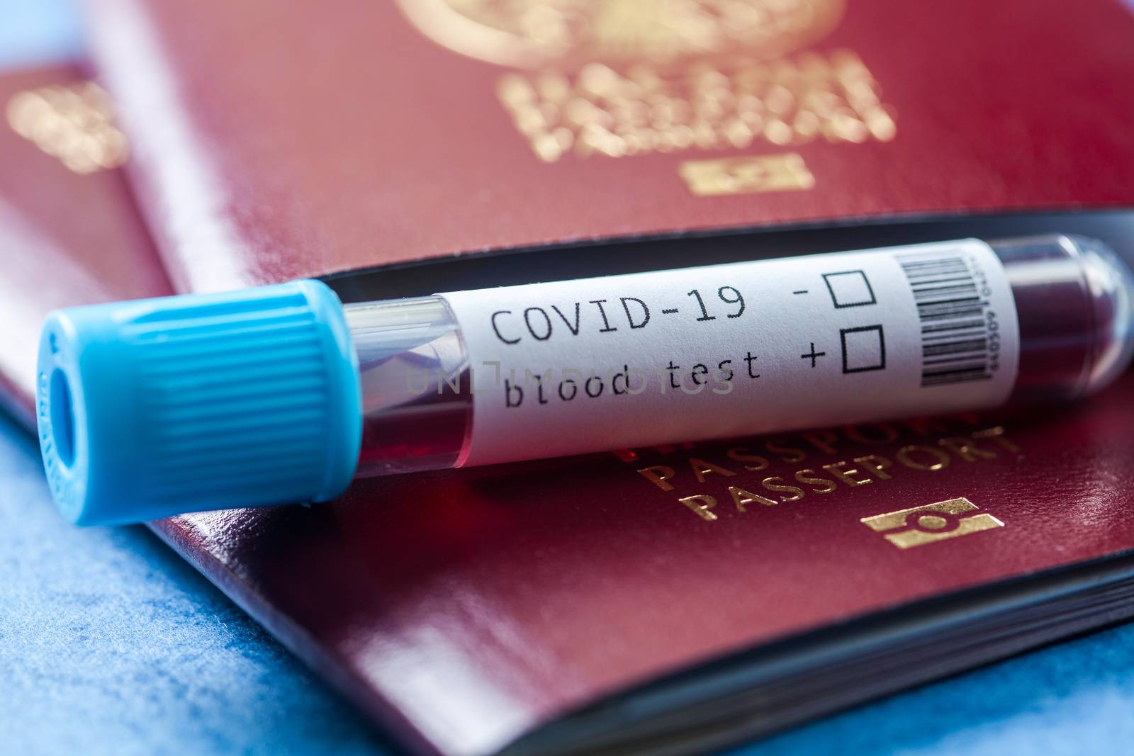 COVID-19 test tube and red passport,passenger blood test at point of arrival concept,travel restrictions due to Coronavirus global pandemic outbreak,prevention of virus spread transmission or transfer