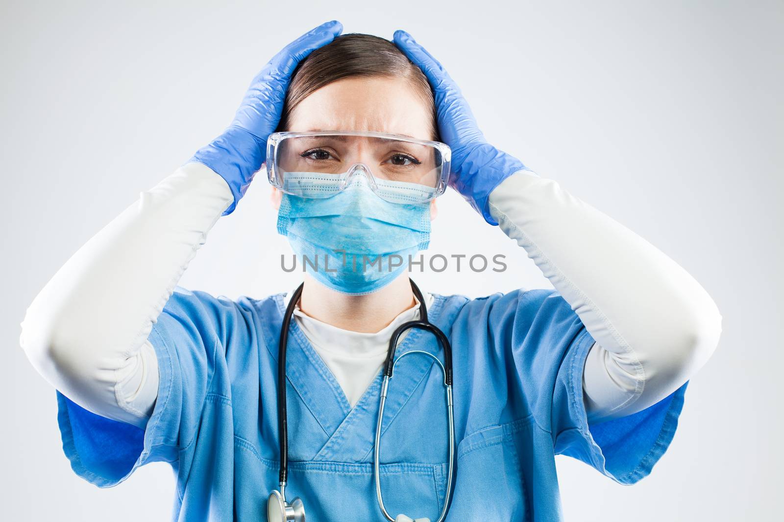 Desperate female doctor,hands on head,worried terrified and devastated medical professional,tragic circumstances leading to numerous dead patients and victims,Coronavirus COVID-19 high mortality rate