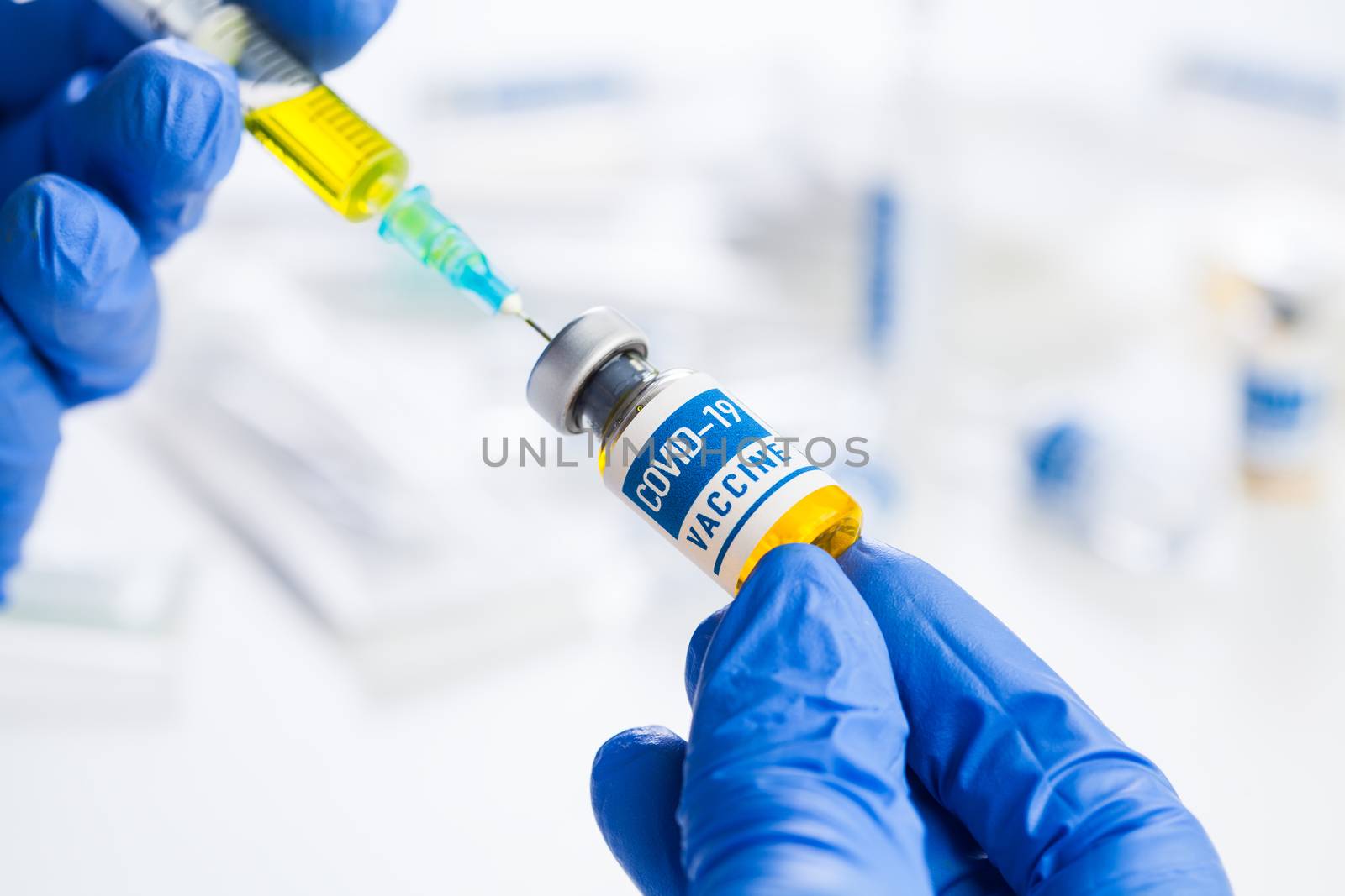 Coronavirus COVID-19 vaccine development,research for cure and treatment of infected patients,groundbreaking discovery in battle against SARS-CoV-2 pathogen,hands in gloves holding ampoule and syringe