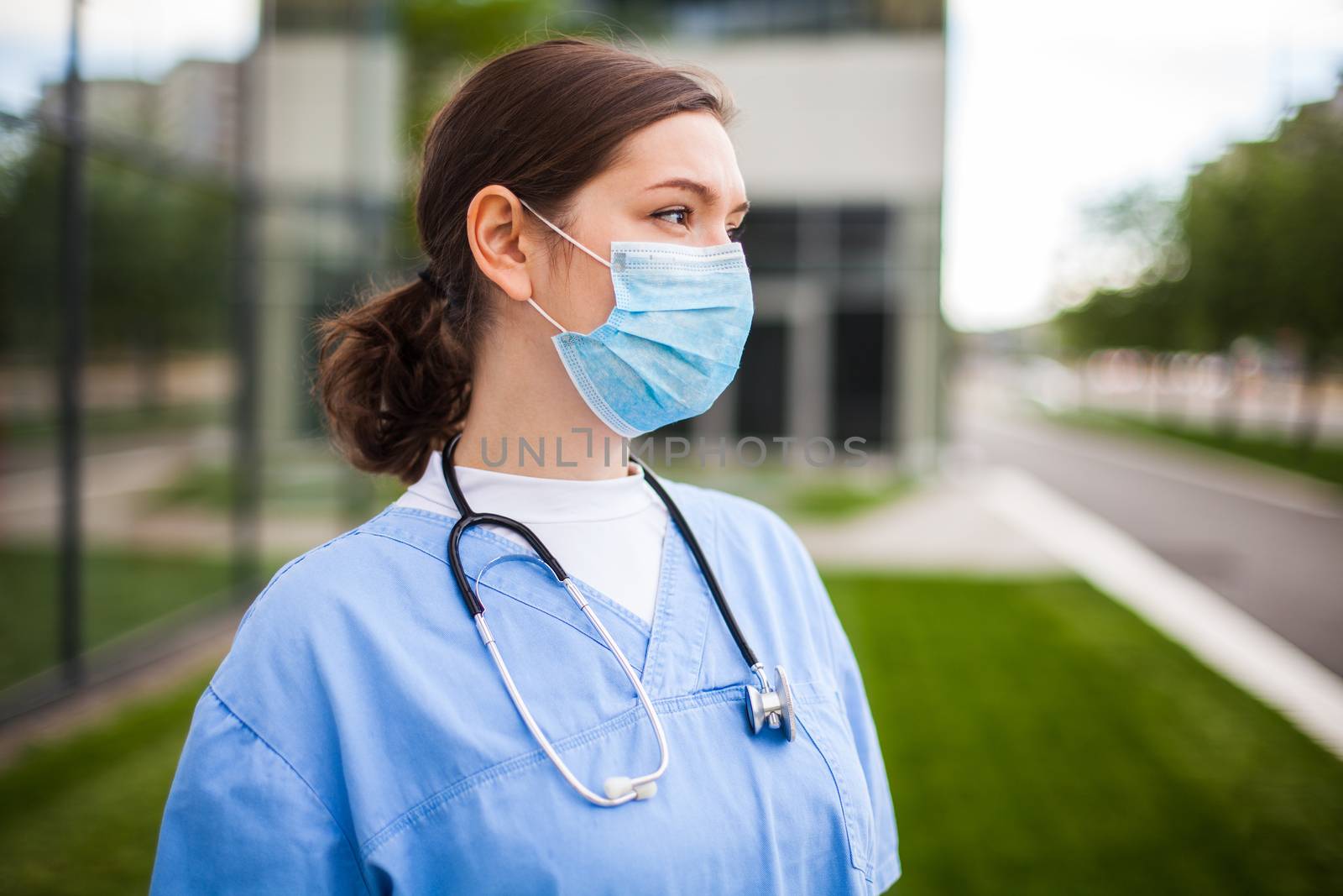 Serious female caucasian doctor looking away with worried facial expression,lost hope due to high mortality rate death toll,Coronavirus COVID-19 pandemic crisis,overworked exhausted EMS staff portrait