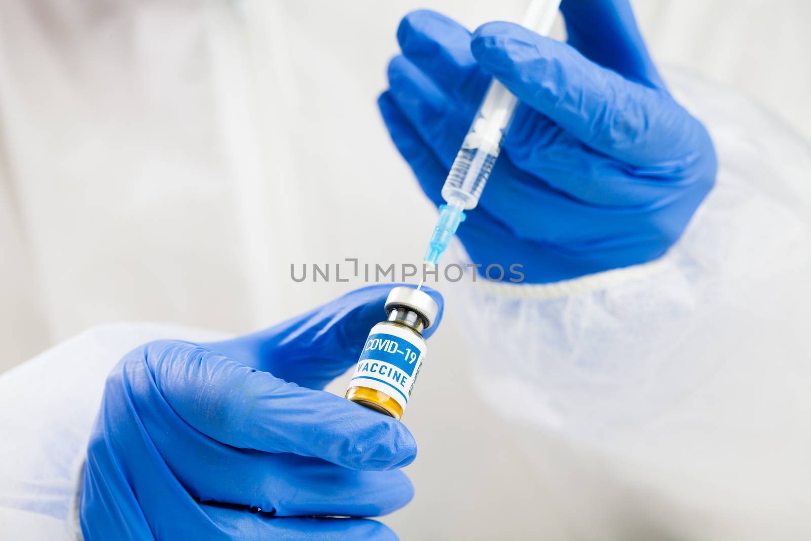 Coronavirus COVID-19 vaccine development,research for cure and treatment of infected patients,groundbreaking discovery in battle against SARS-CoV-2 pathogen,hands in gloves holding ampoule and syringe