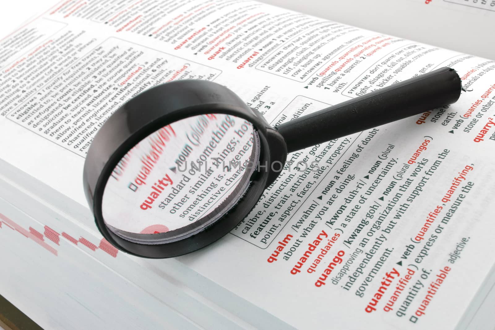 A magnifying glass focussed on the word quality. Quality assurance control enhancement business concept