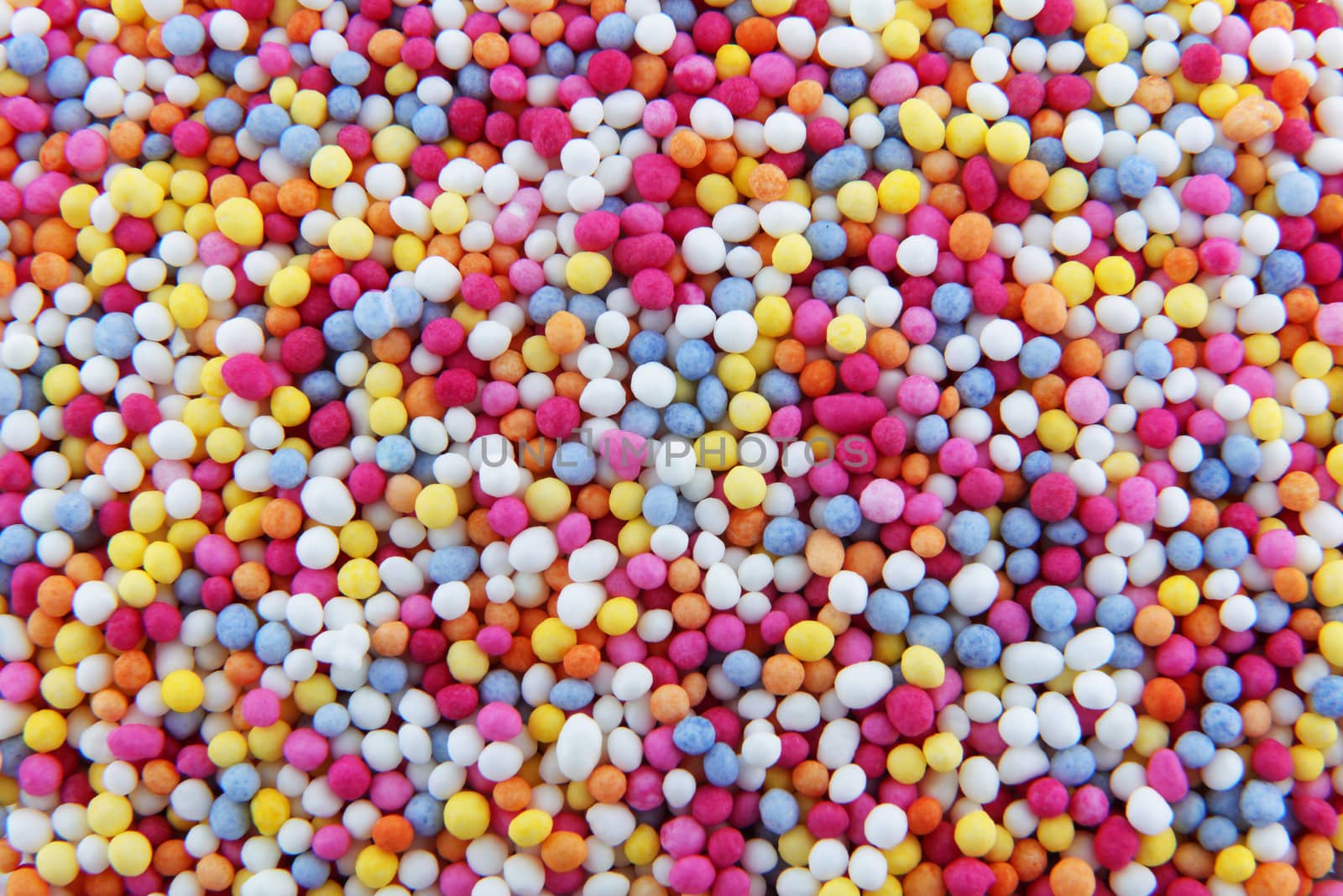 Some hundreds and thousands sprinkles tiny sugar beads of varying colours used for decorating cakes and desserts background texture