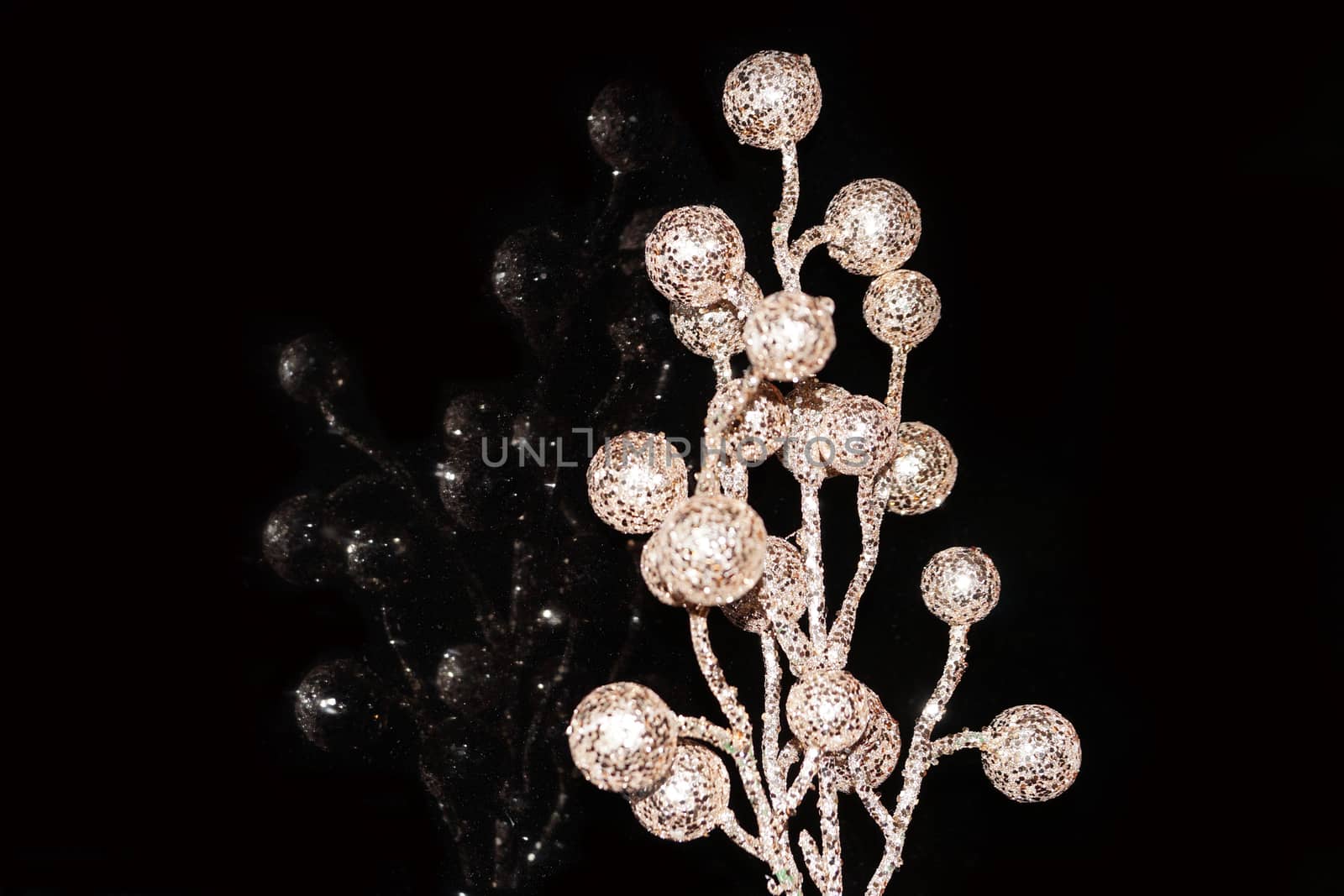 shiny branch with balls reflected in black glass close up
