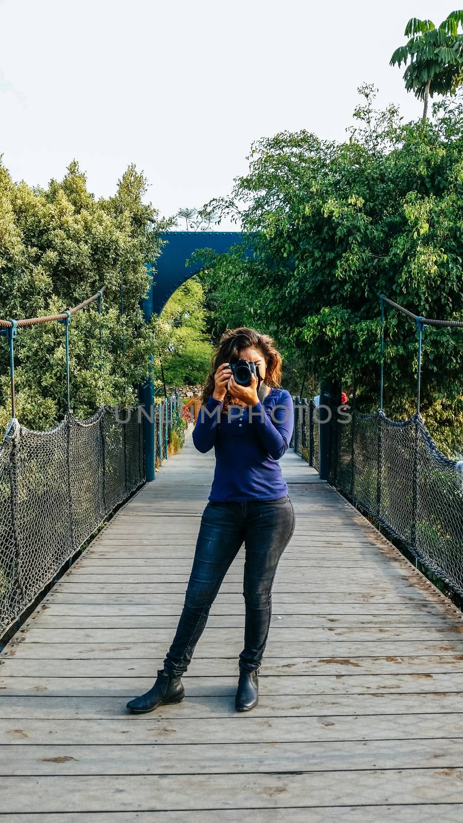 Outdoor summer smiling lifestyle portrait of pretty young woman having fun in the city of Lima taking pictures with her camera