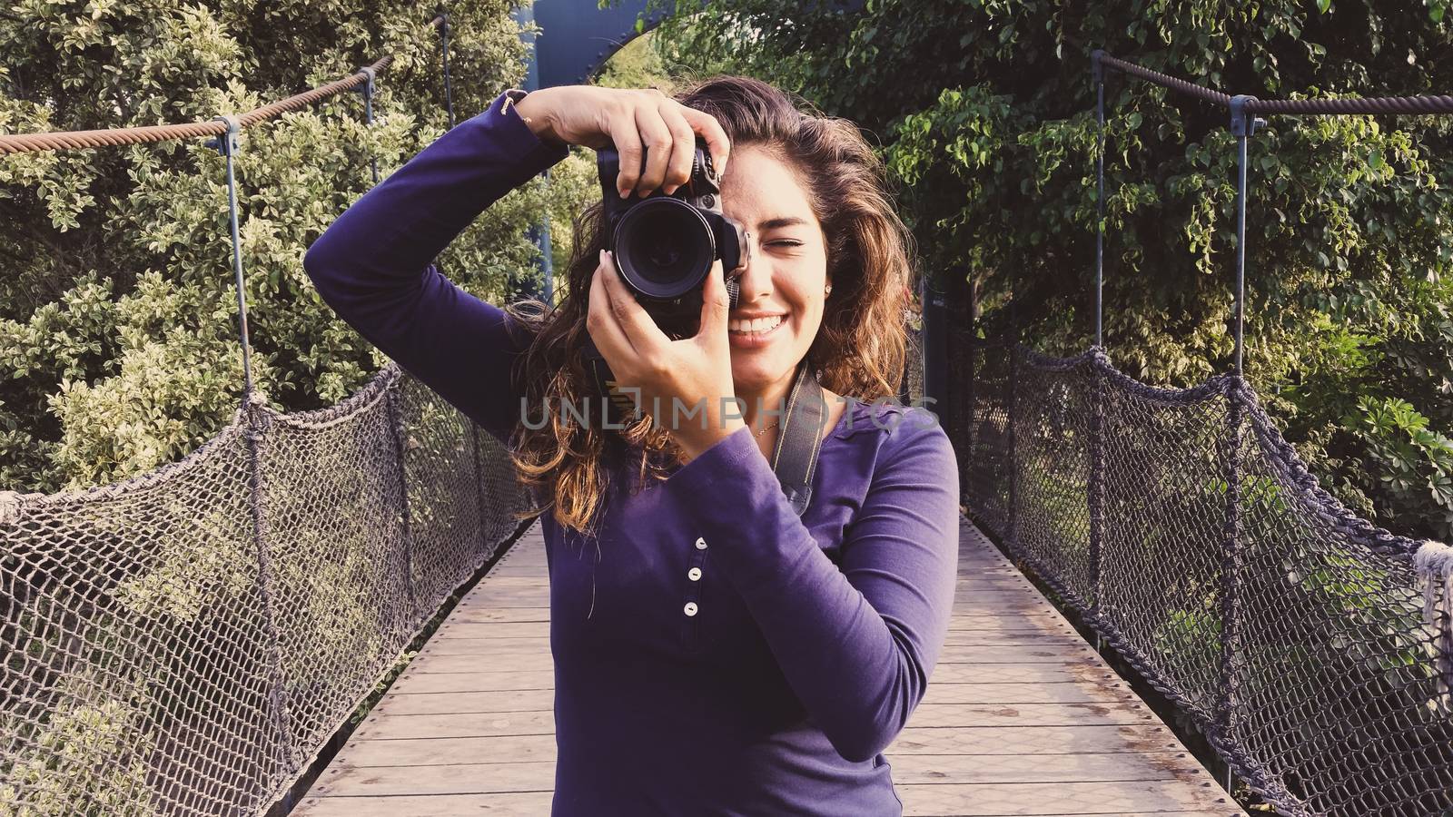 Outdoor summer smiling lifestyle portrait of pretty young woman having fun in the city of Lima taking pictures with her camera