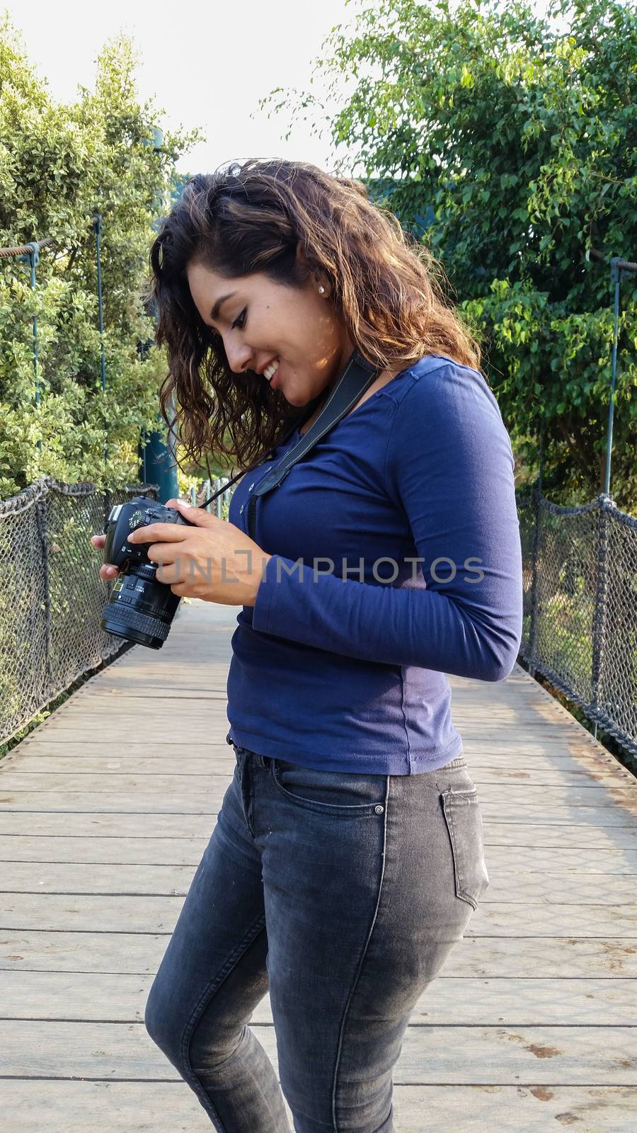 Outdoor summer smiling lifestyle portrait of pretty young woman having fun in the city of Lima taking pictures with her camera