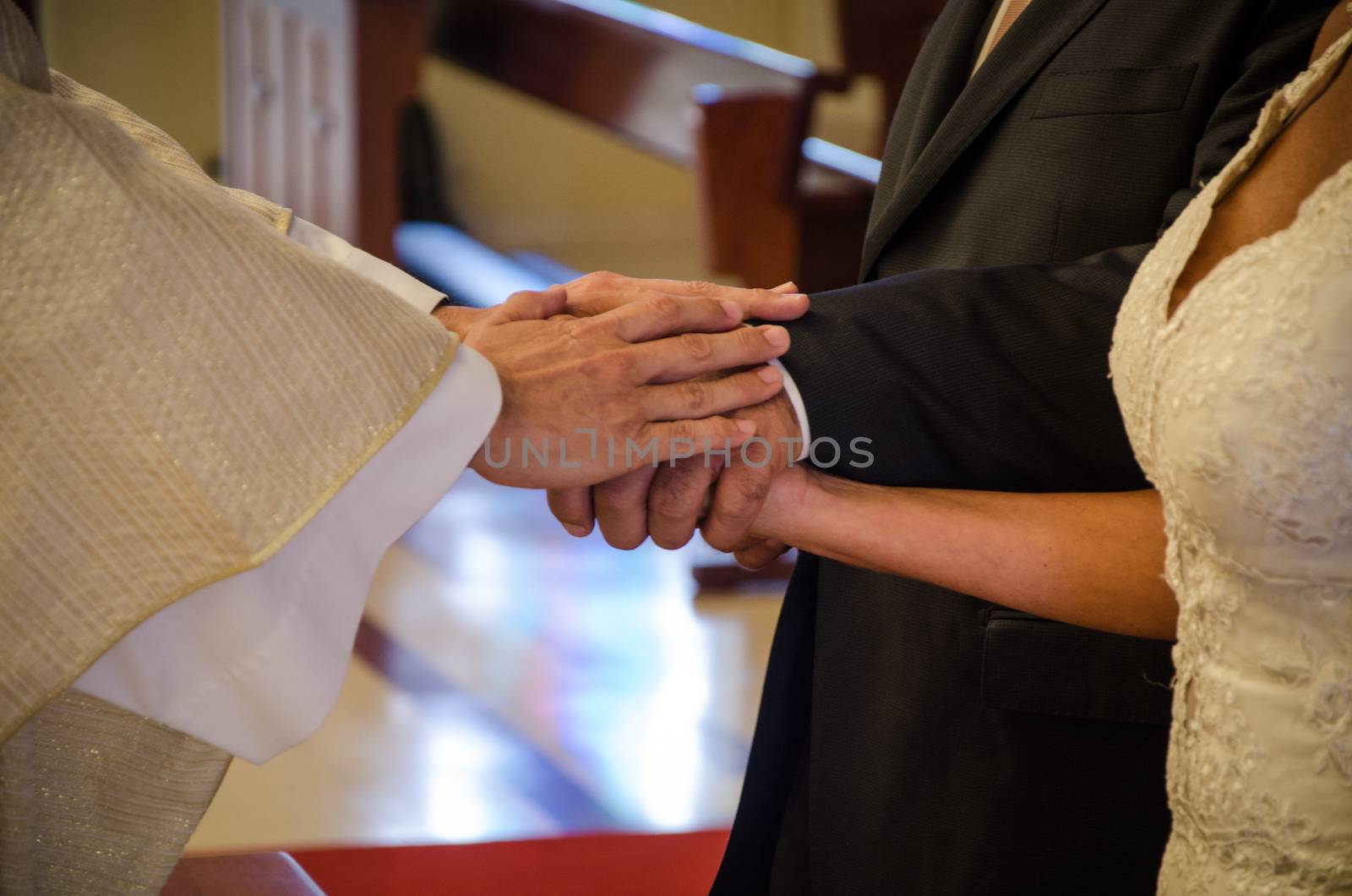 Blessing of the rings: hands of the priest and hands of the united couple
