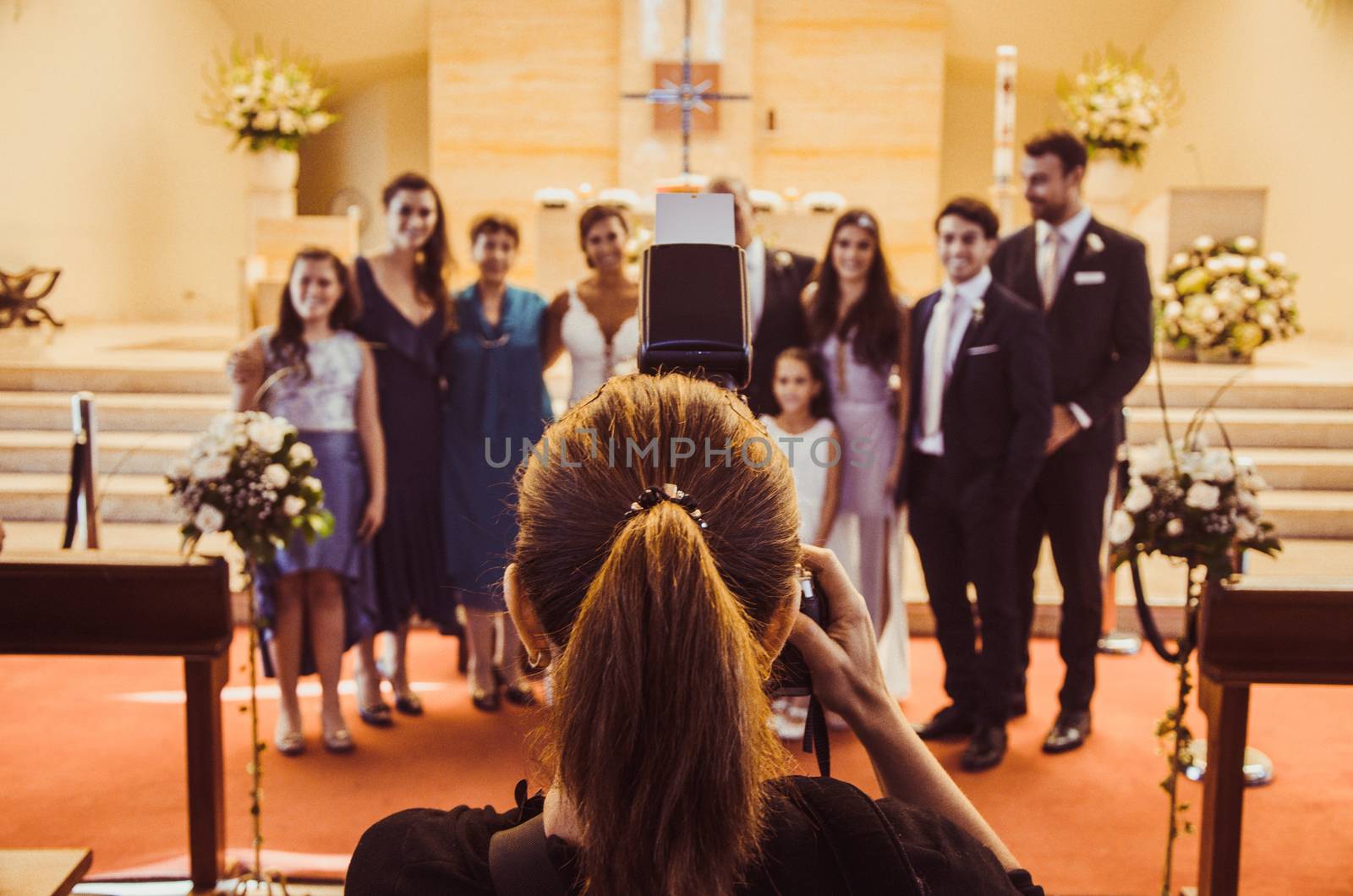 Professional wedding photographer in action in a church