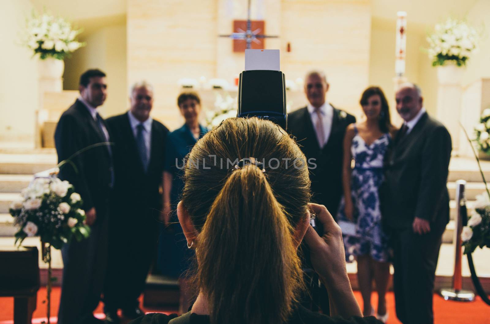 Professional wedding photographer in action in a church