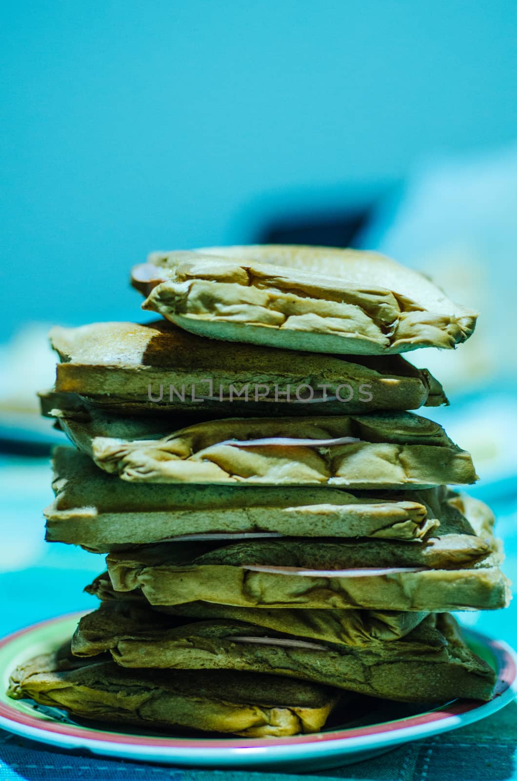 Tower of ham and cheese sandwiches on a white plate