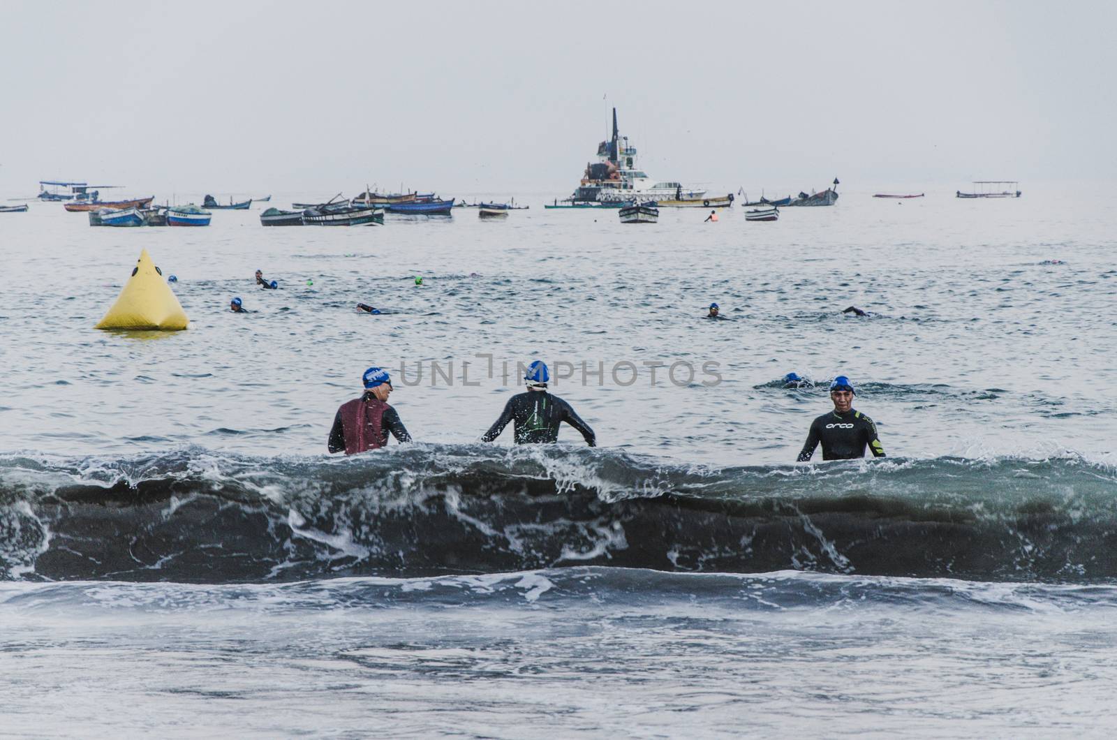 LIMA, PERU - APRIL 22th 2018: Ironman 70.3 . Athletes entering the sea and others leaving