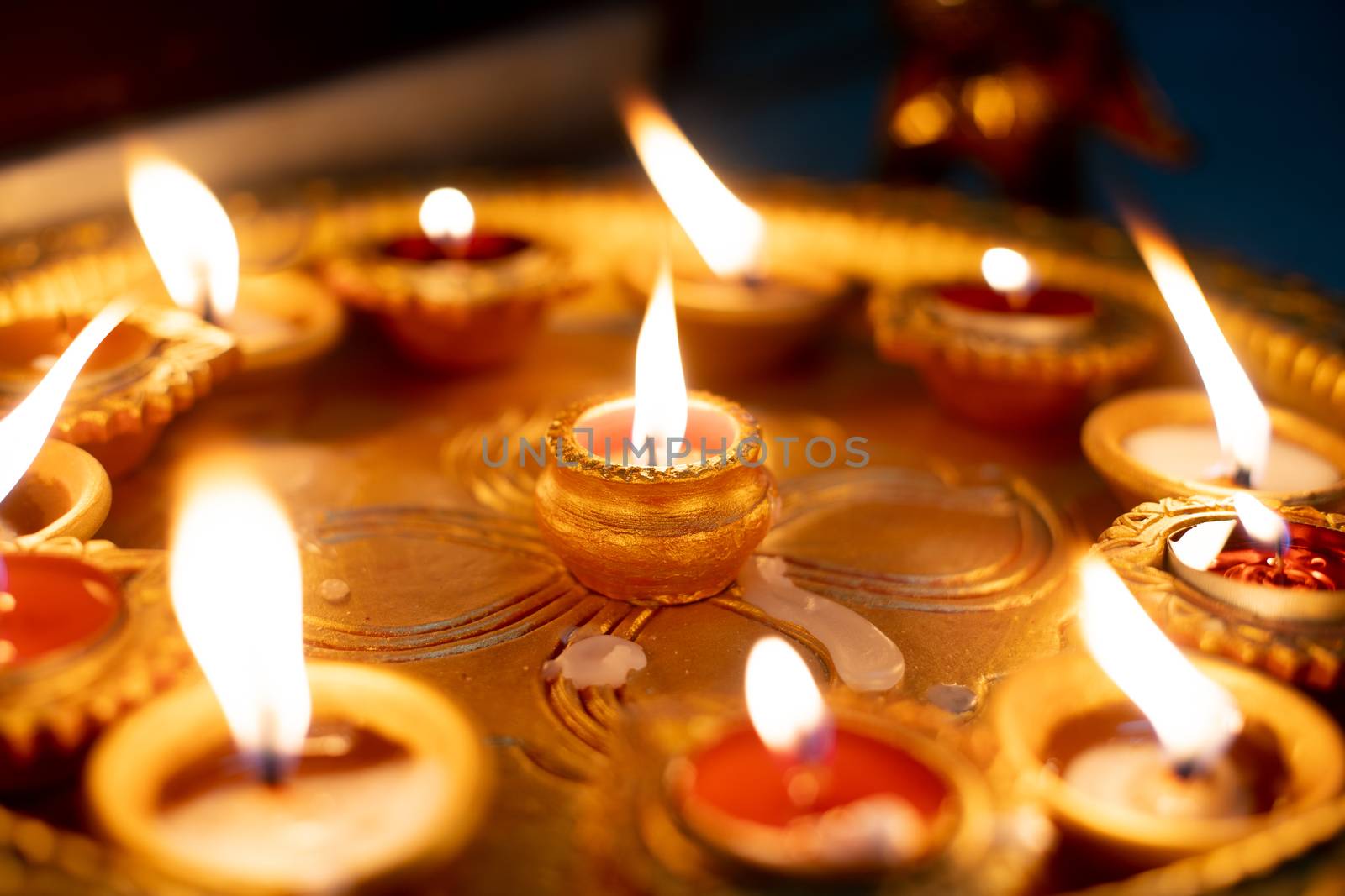 Macro shot showing colorful earthenware diya oil lamps with a little cotton wick to burn oil for light often used as decoration on the hindu festival of diwali showing the victory of good over evil. Shows the beautiful decorations on the hindu festival of diwali where small earthen lamps filled with oil are lit to show the victory of good over evil