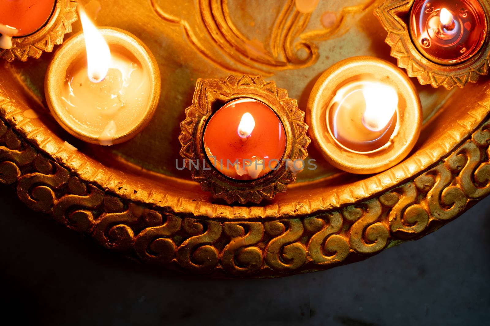 Half frame shot showing colorful earthenware diya oil lamps with a little cotton wick to burn oil for light often used as decoration on the hindu festival of diwali showing the victory of good over evil. Shows the beautiful decorations on the hindu festival of diwali where small earthen lamps filled with oil are lit to show the victory of good over evil