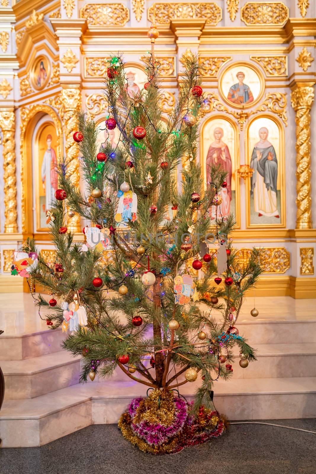 Decorated Christmas tree with toy angel in Orthodox church. Merry Christmas religious concept