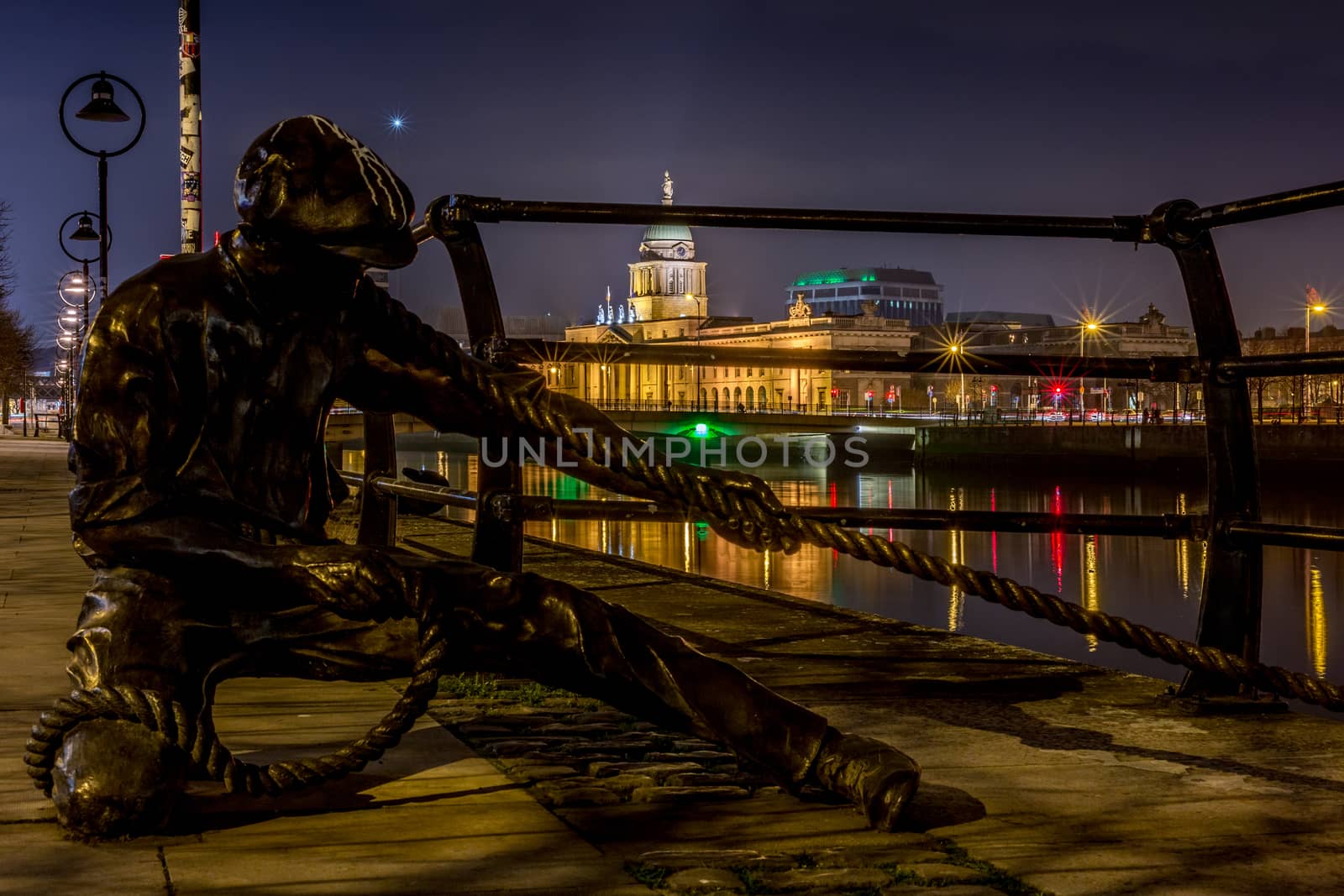 Sculpture of sailor pulling rope on River Liffey, Dublin, Ireland at night by mlechanteur