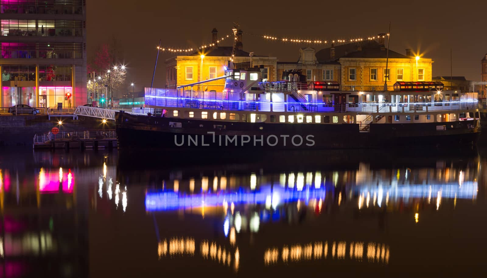 Party boat with lights on river liffey dublin ireland at night