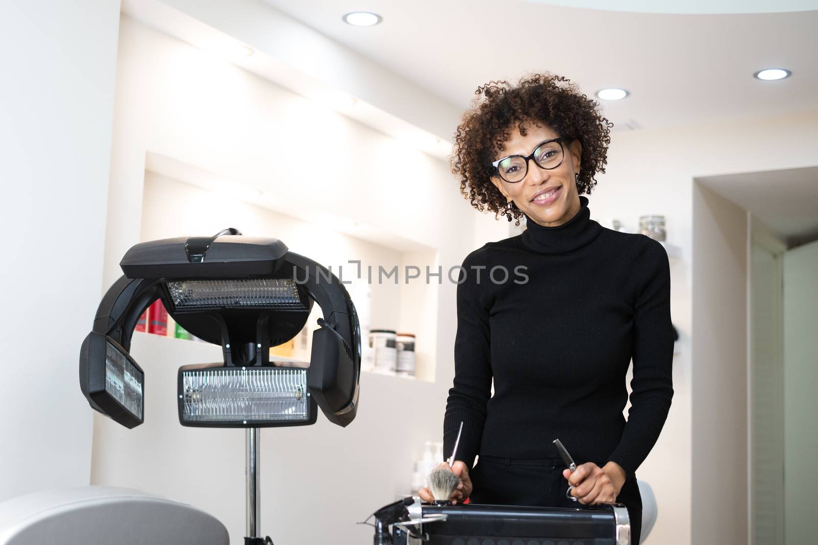Black female hairdresser standing in salon by Dumblinfilms
