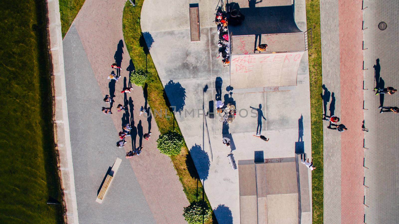 Young people dancing, singing and playing sports on the city s waterfront, aerial shooting from drone. Surrealism by TrEKone