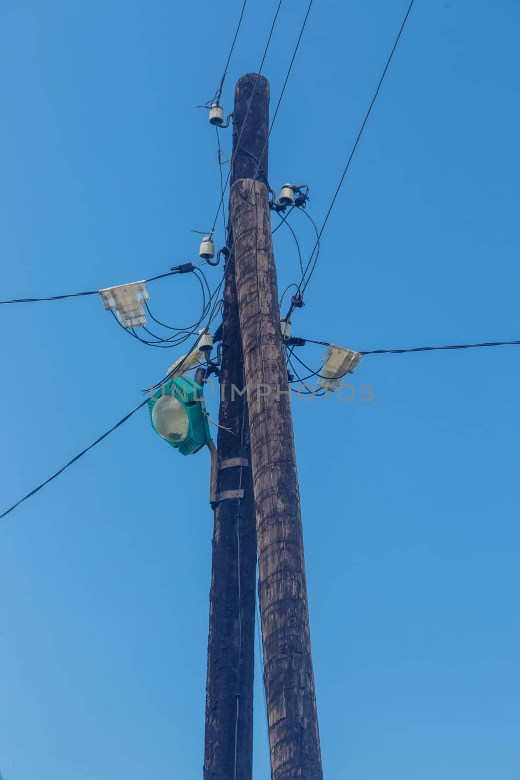 Electric pole with lamps and wires against Blue Sky.