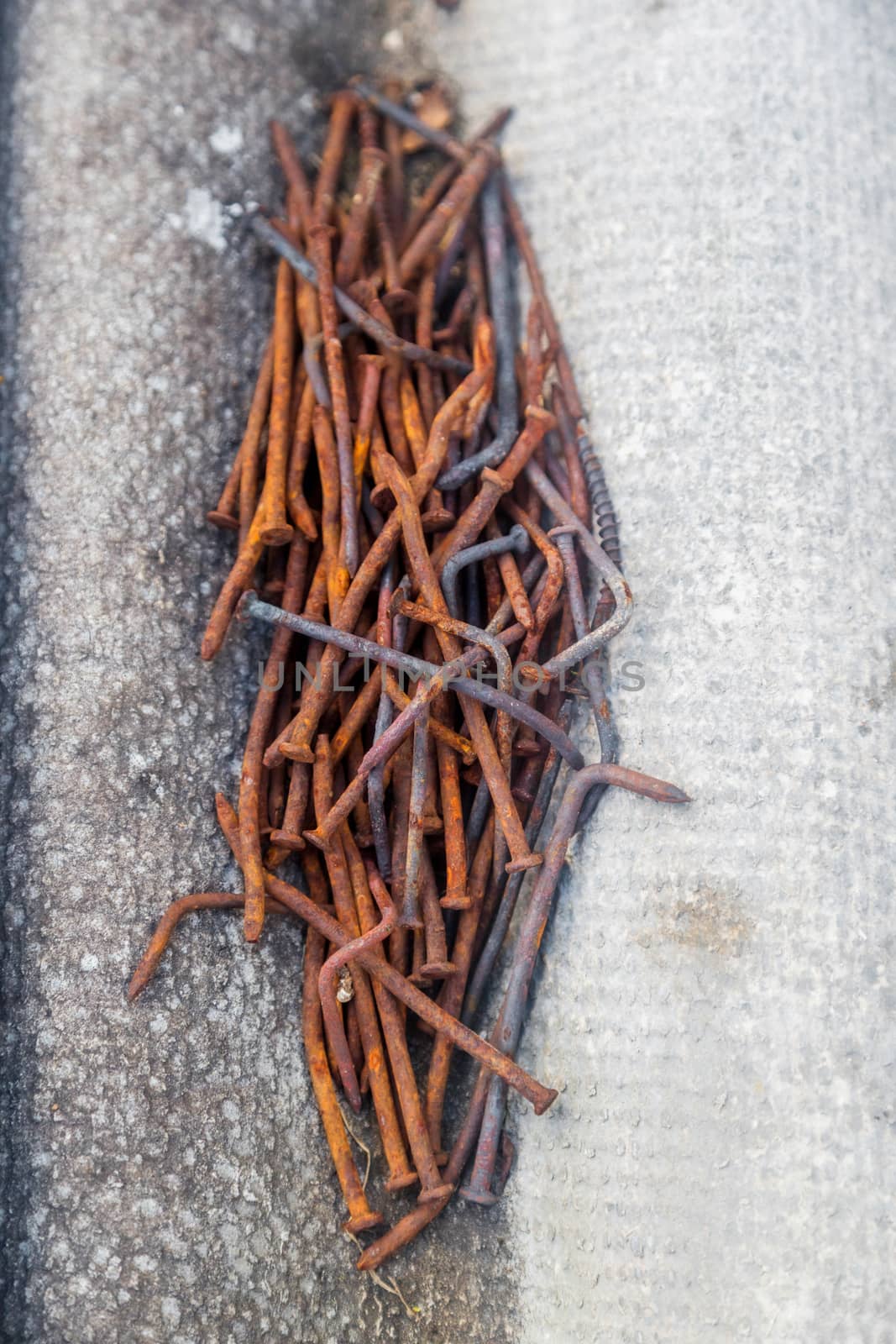 A handful of old bent rusty nails on a piece of slate by galinasharapova