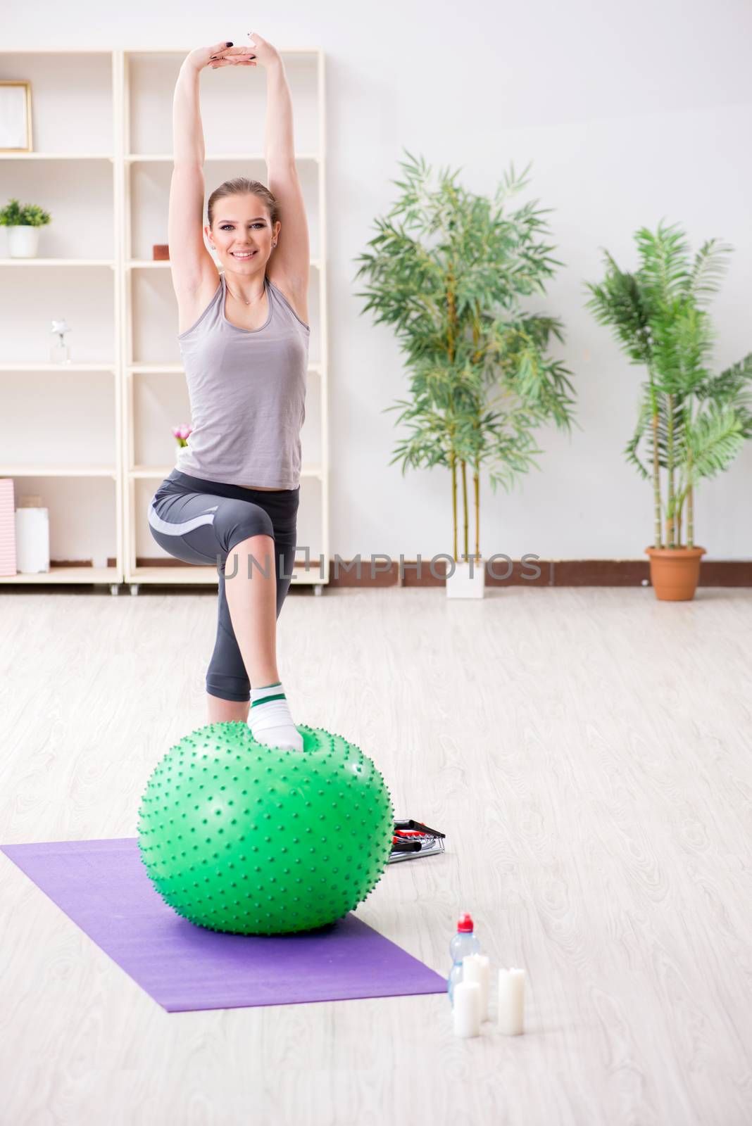 Young woman exercising with stability ball in gym by Elnur