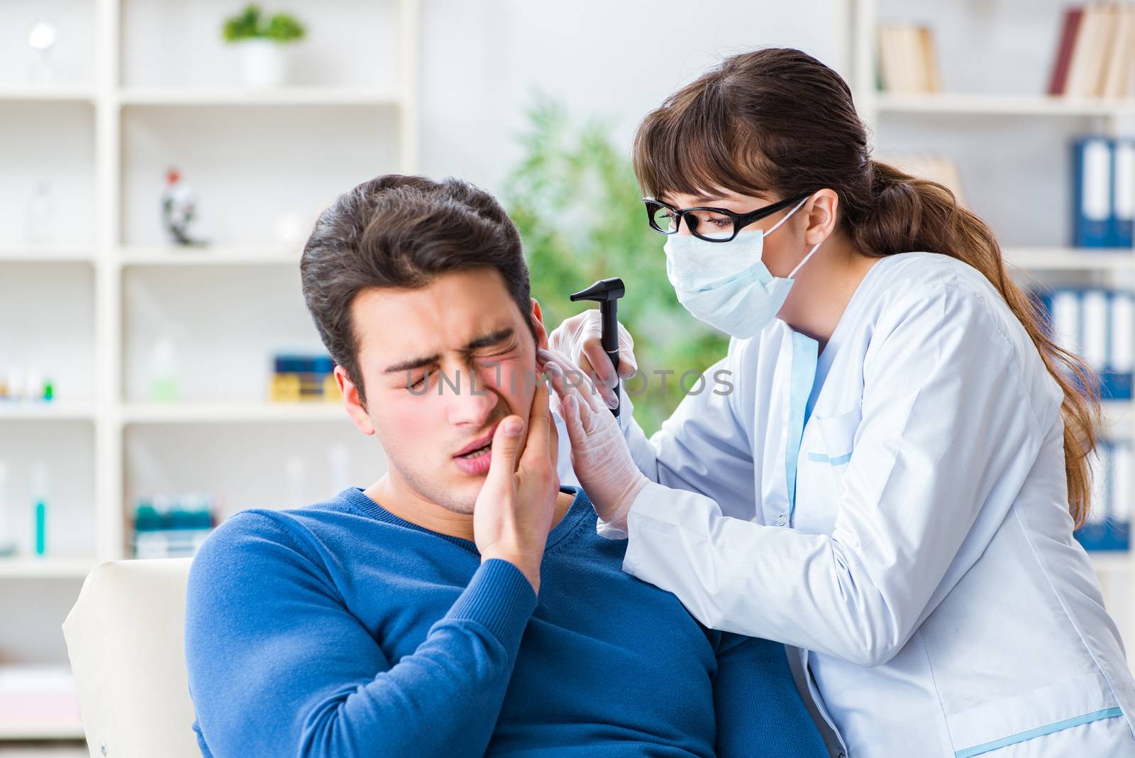 Doctor checking patients ear during medical examination by Elnur