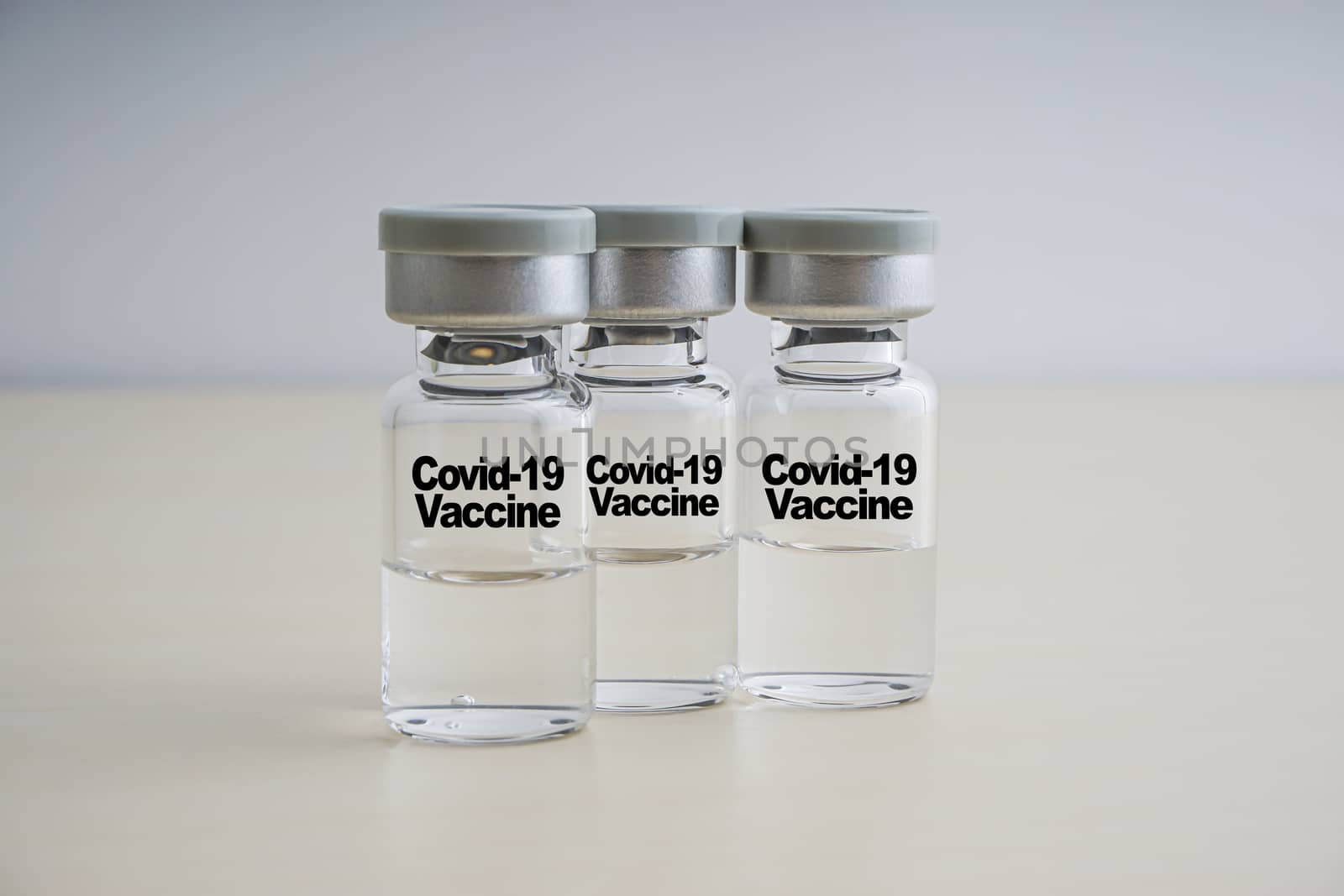 COVID-19 VACCINE text with vials on wooden background by silverwings