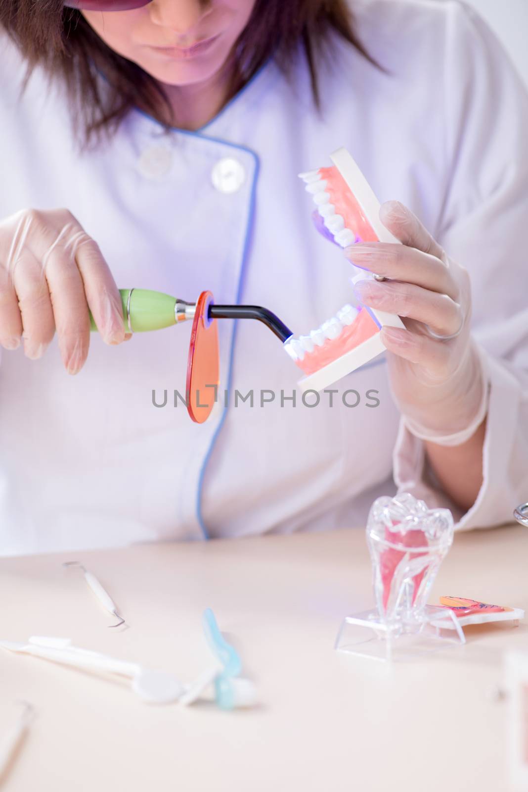 Woman dentist working on teeth implant by Elnur