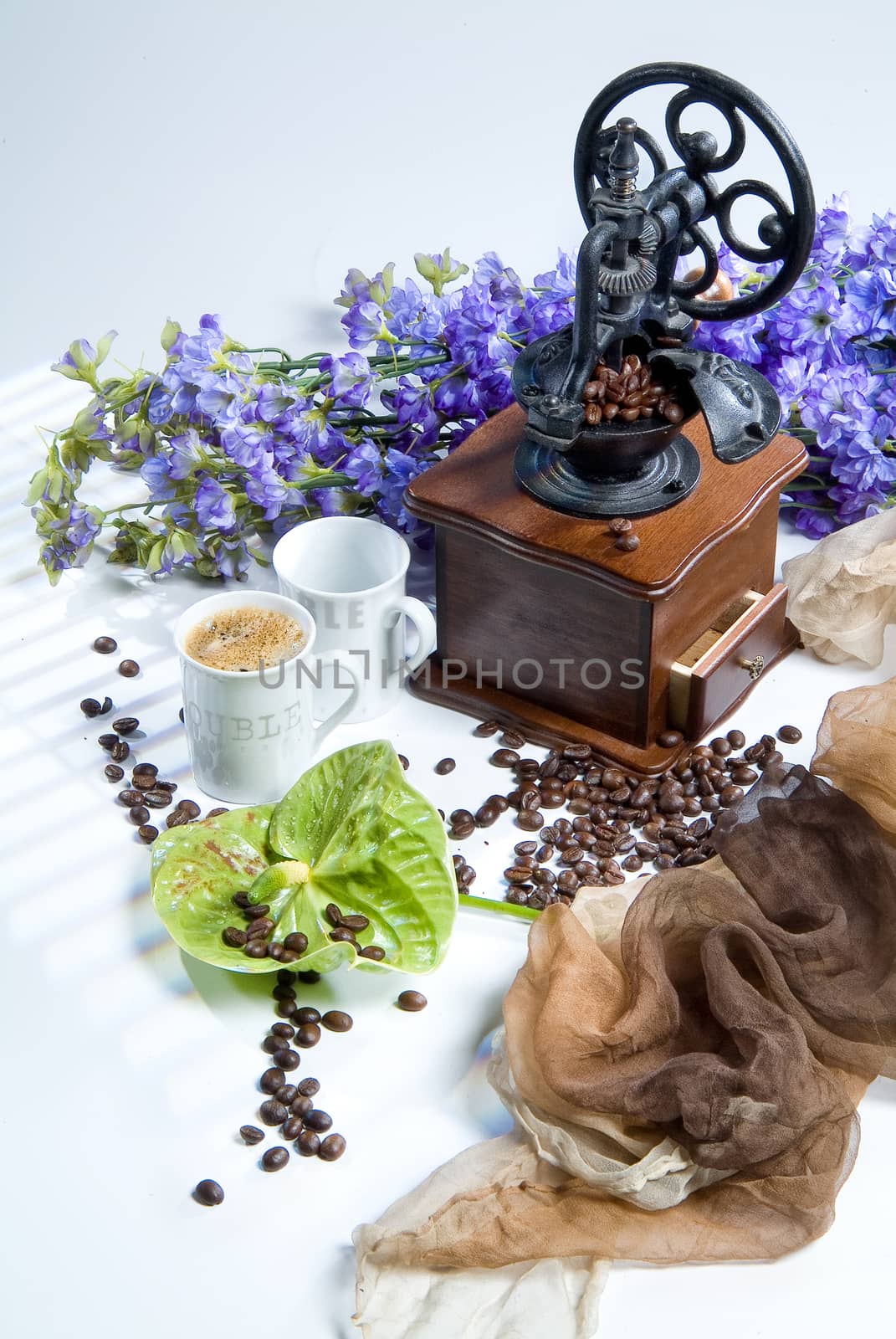 Coffee mill, cup and coffee beans on a studio background