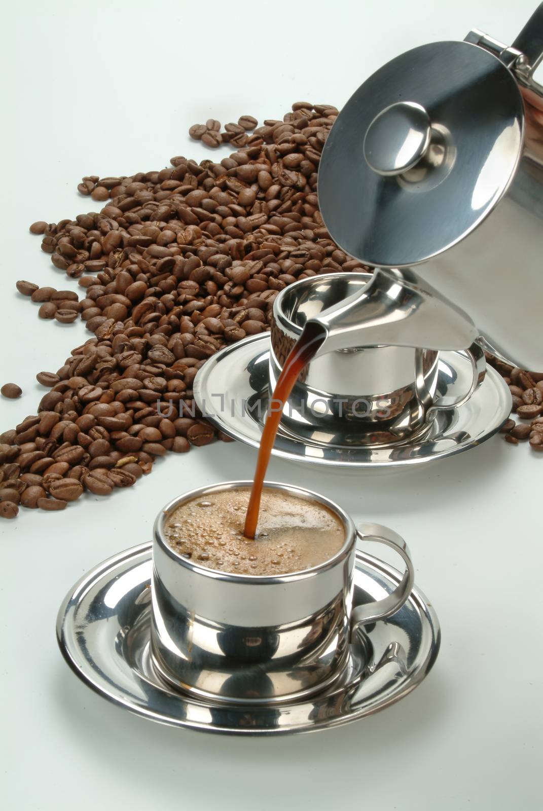 Cup of coffe, beans and tableware on a studio background