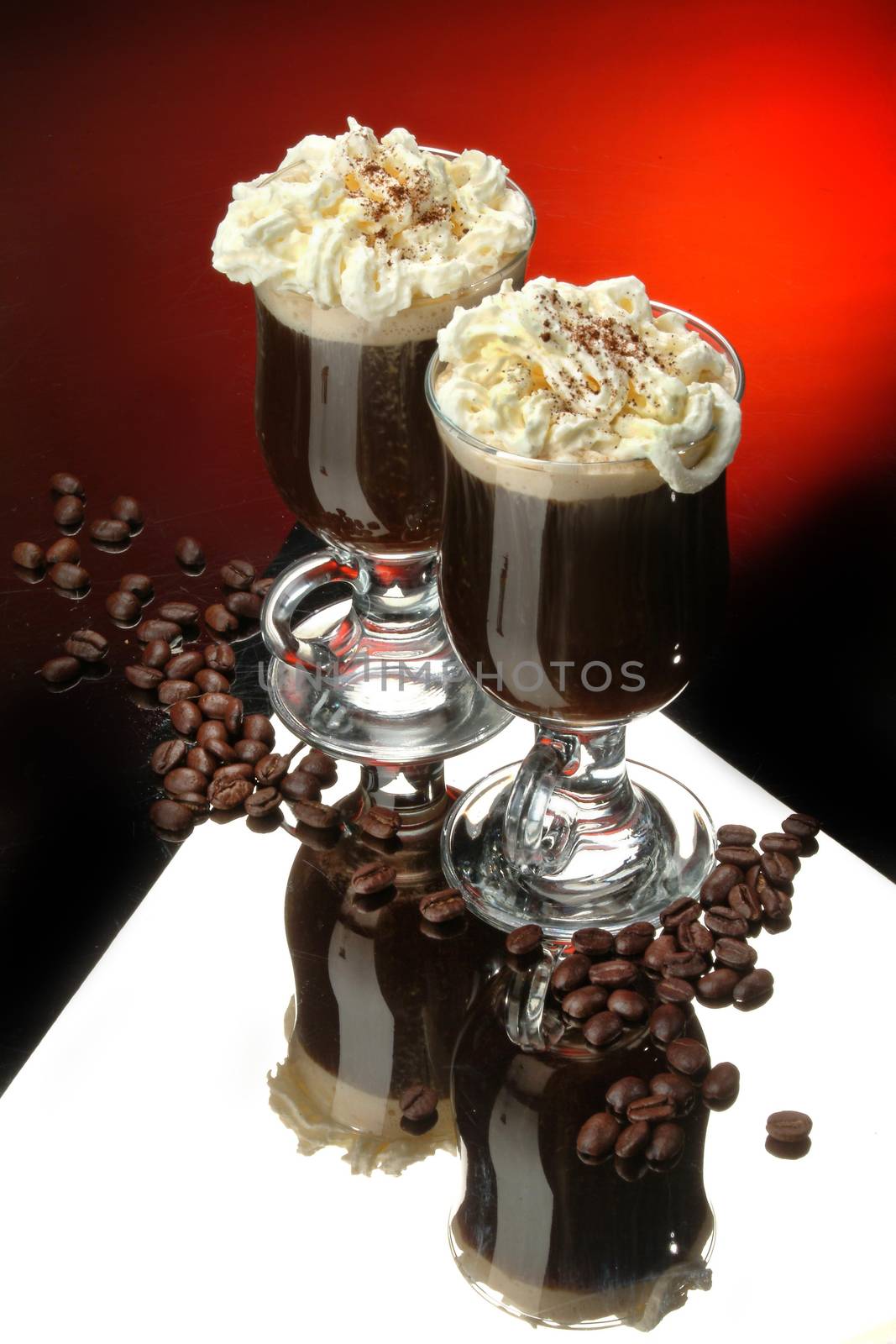 Two glasses with coffee and cream on a glass background