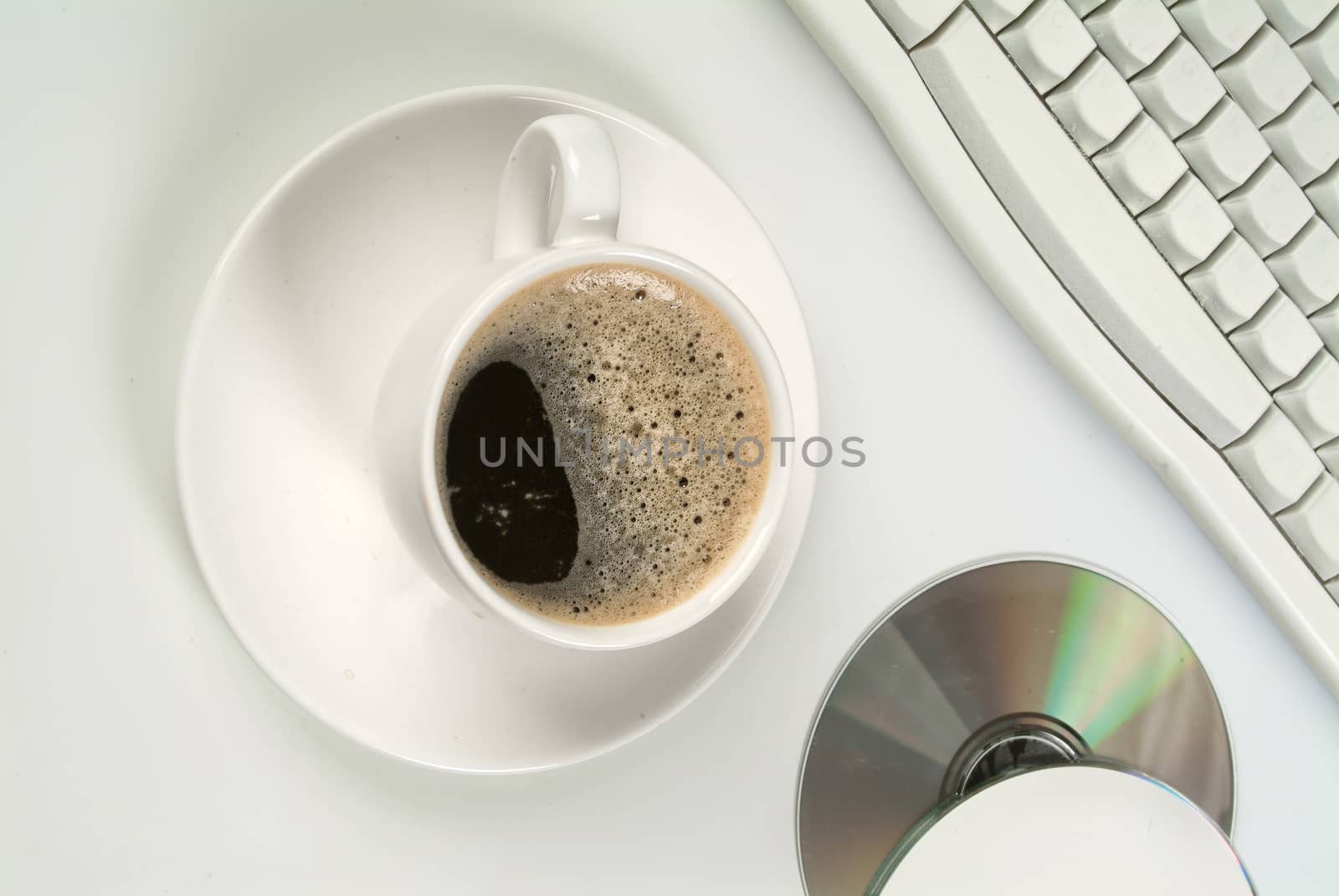 Cup of coffee, discs and keyboard on a studio background
