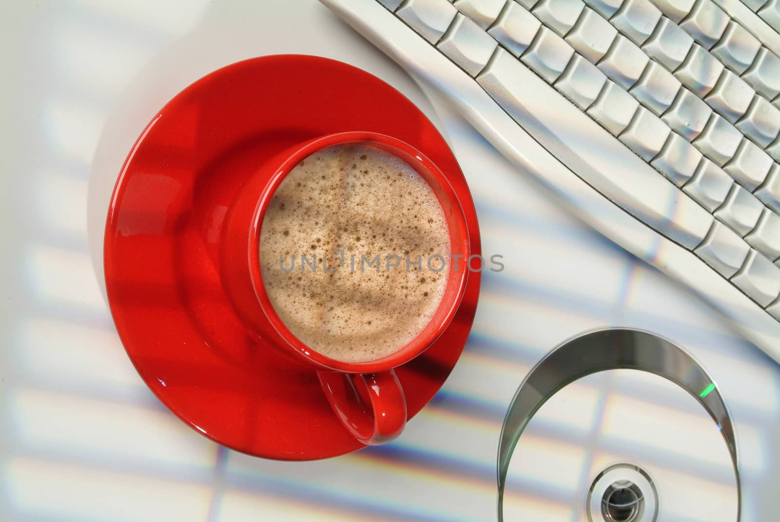 Cup of coffee, discs and keyboard on a studio background