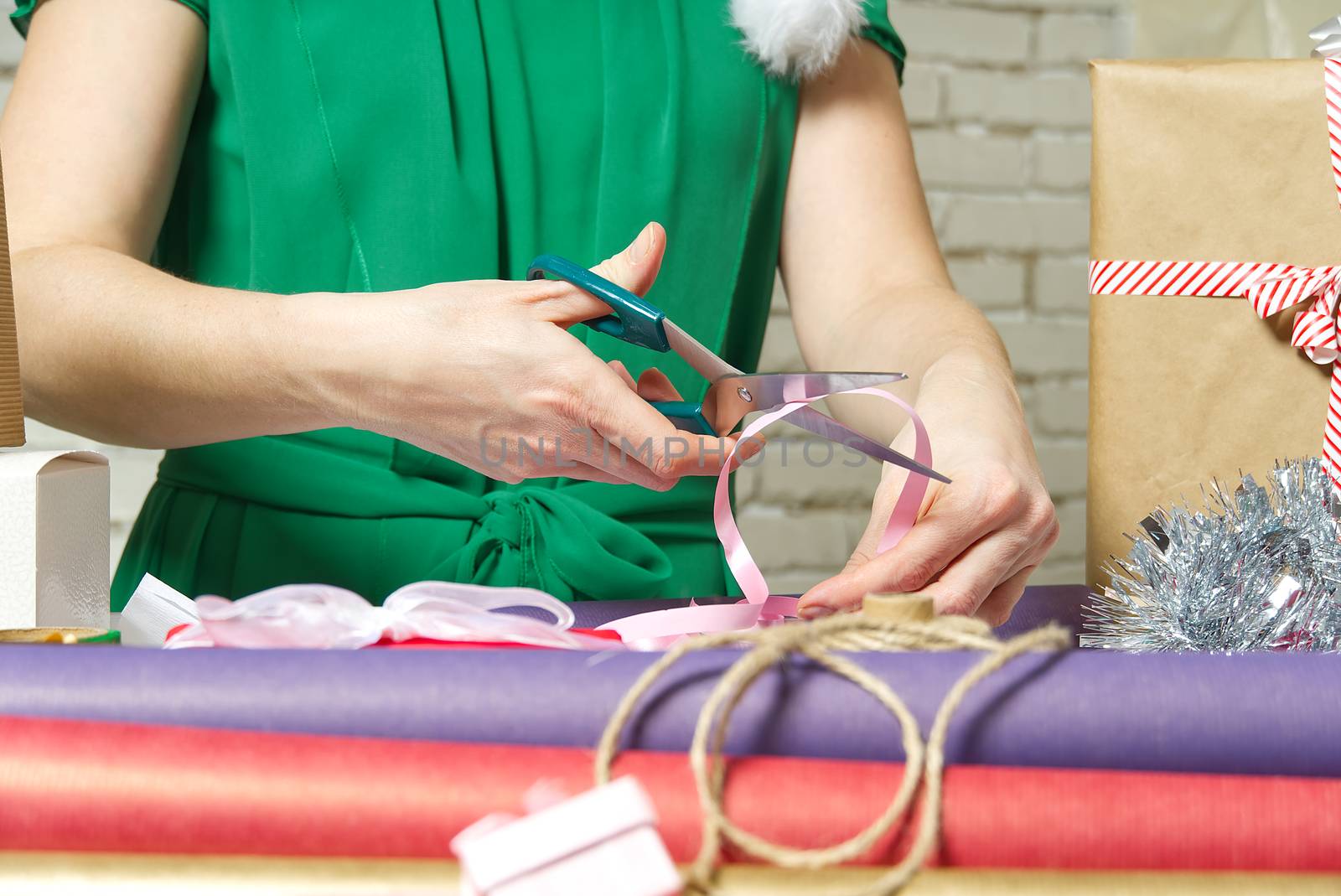 Woman wrapping christmas presents to violet packing paper. woman hands packing a christmas gift, diy gift packing and wrapping concept.