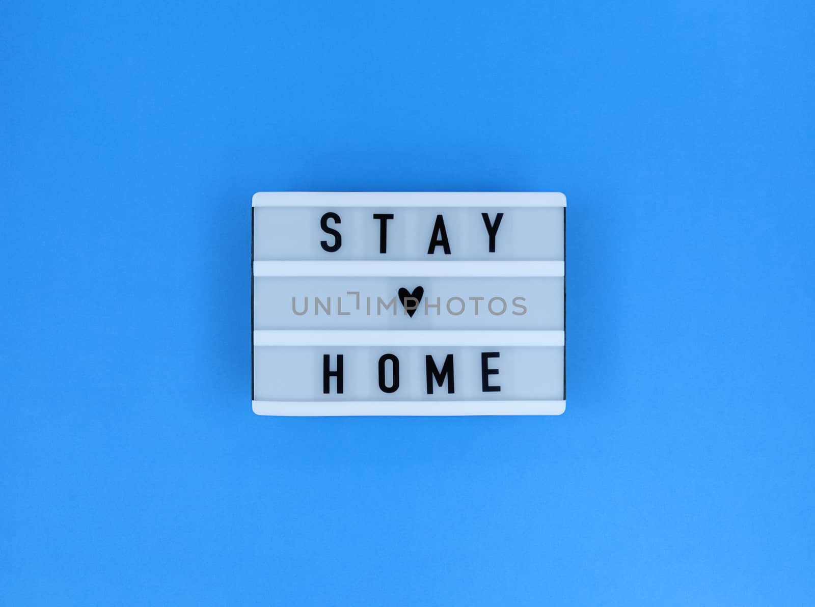 Light box with Stay home quote on blue background.