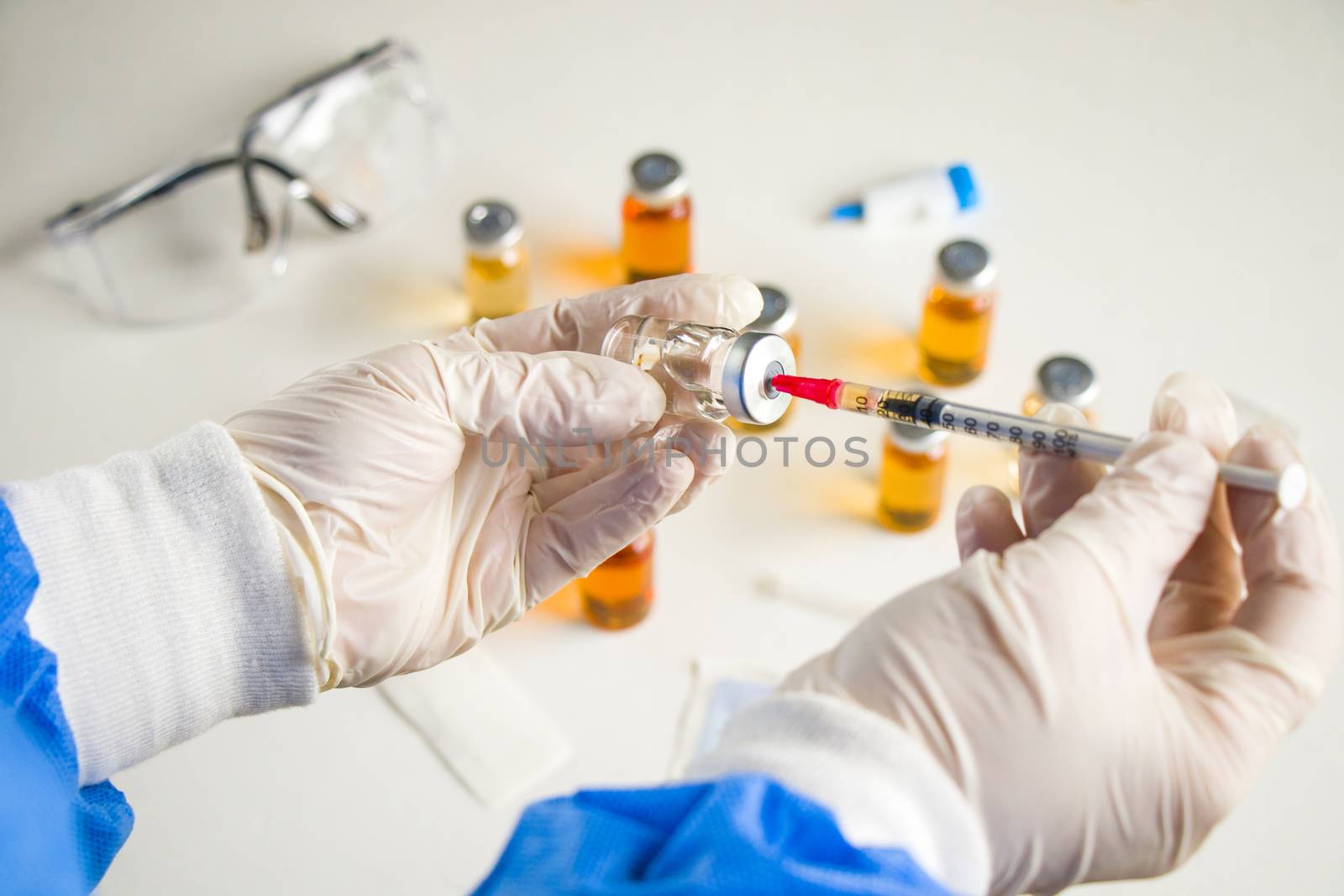 Corona virus and Covid - 19 new vaccine in ampules and bottles, needle and doctors hands with glove.