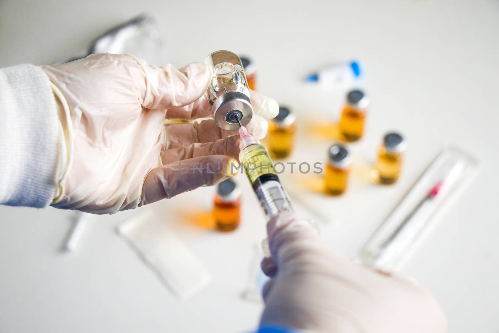 Corona virus and Covid - 19 new vaccine in ampules and bottles, needle and doctors hands with glove.