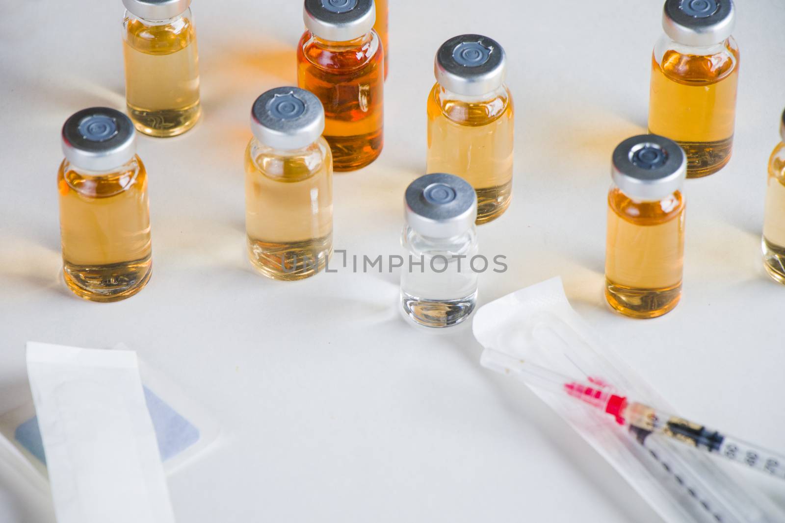 New vaccine in ampules and bottles, needle, glove and safety glass. by Taidundua